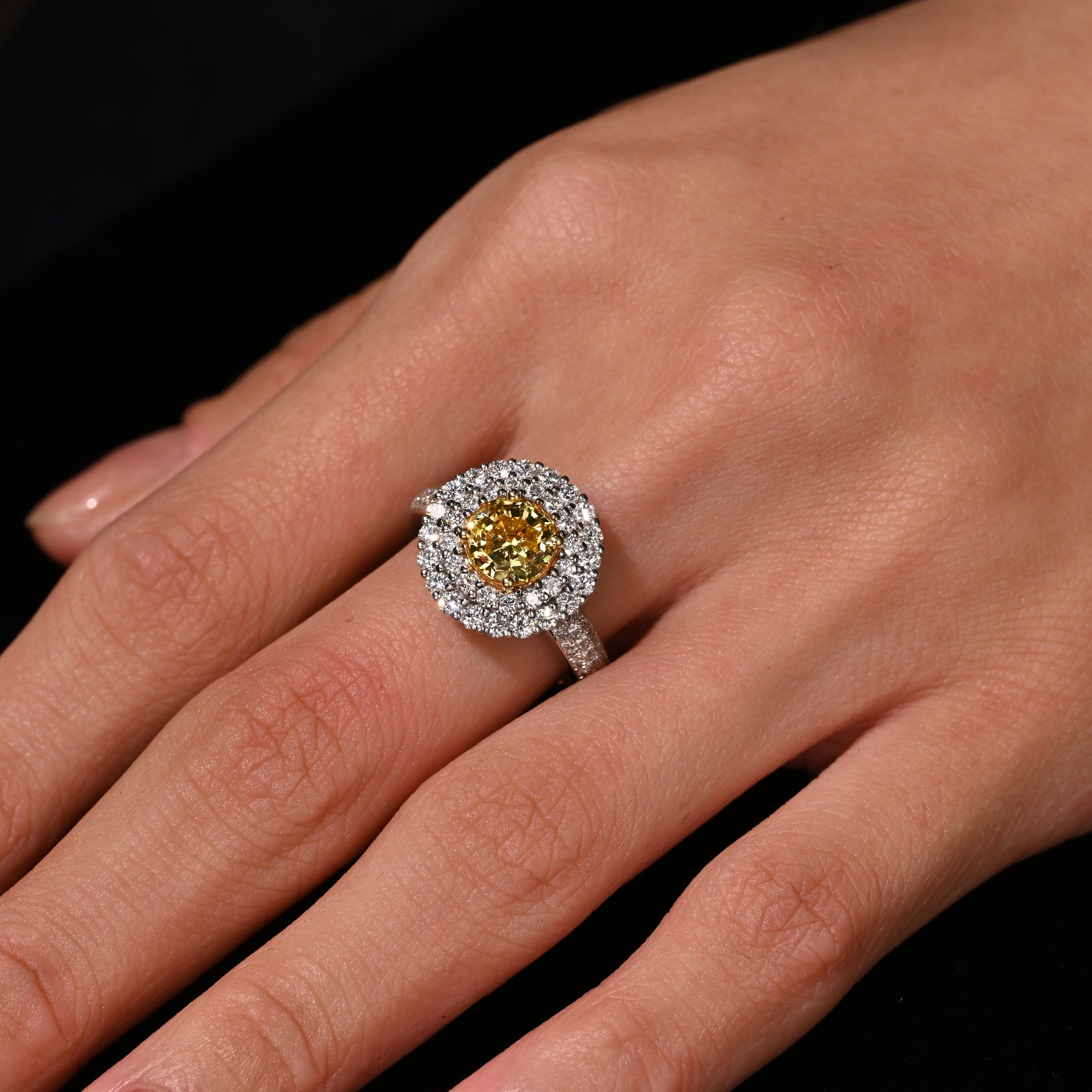 GIA Certified 1.65 carat Fancy Intense Yellow modified brilliant cut diamond with a double halo of white diamonds and diamond shank in 18k white gold. The diamond is VVS1 clarity and features a unique cut that is seldom seen. It's a modified