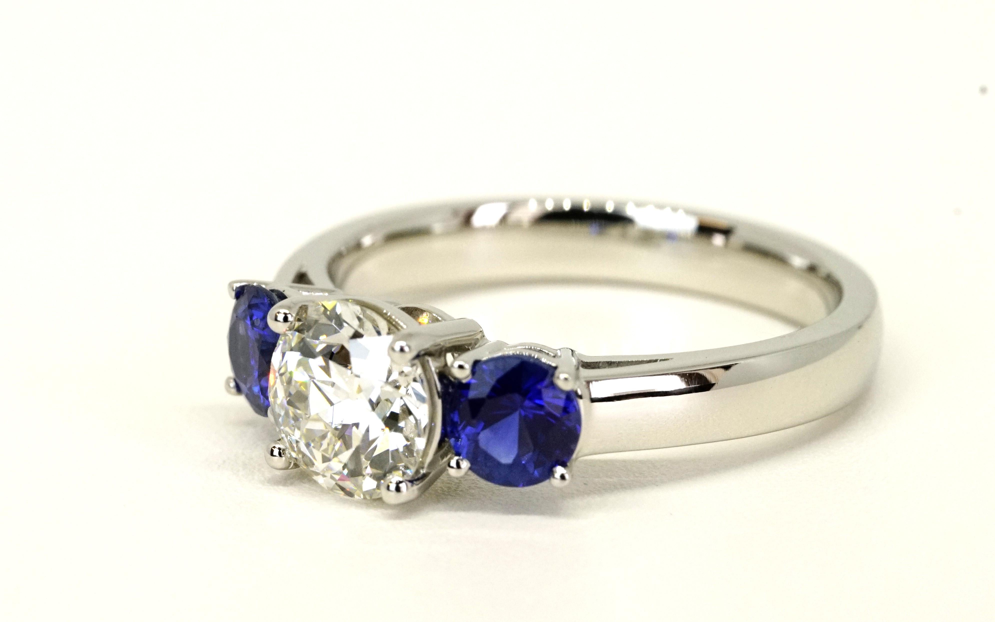 Old European Cut Diamond 1.05 Carat G SI1 GIA center set in a classic three stone Platinum ring with 0.60 carats total weight of natural deep blue sapphires. 
The Diamond is estimated to be cut in the early 1930's which gives this modern three stone
