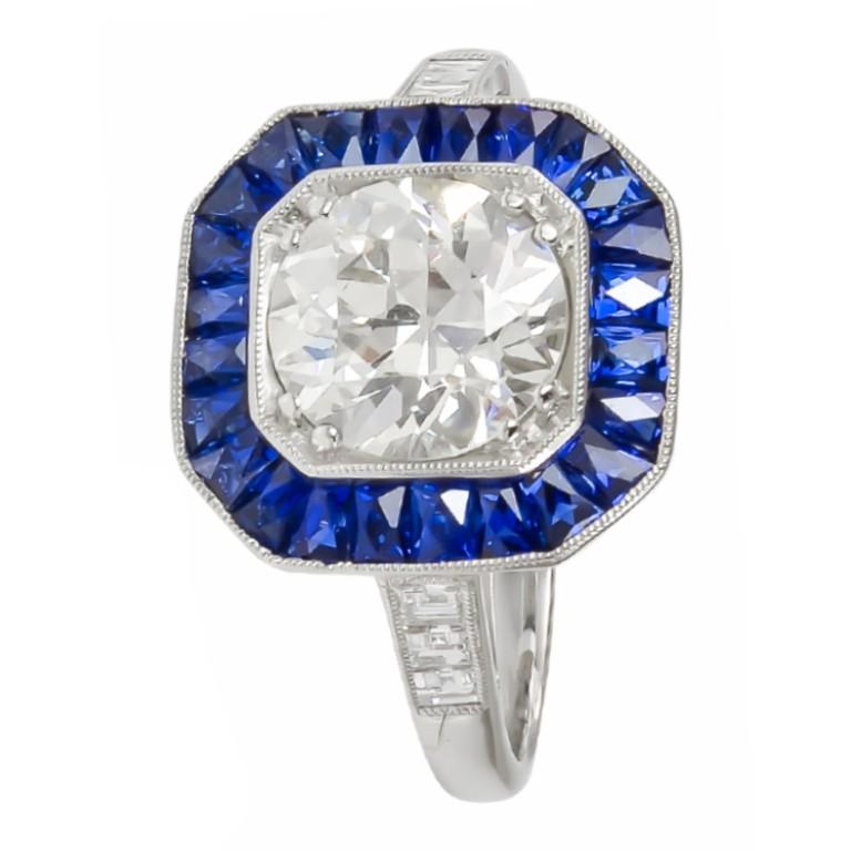 Tailored platinum 1.66 carat round cut center diamond surrounded by 0.75 carat french cut sapphire and smaller diamonds on the shank weigh 0.10 ring
