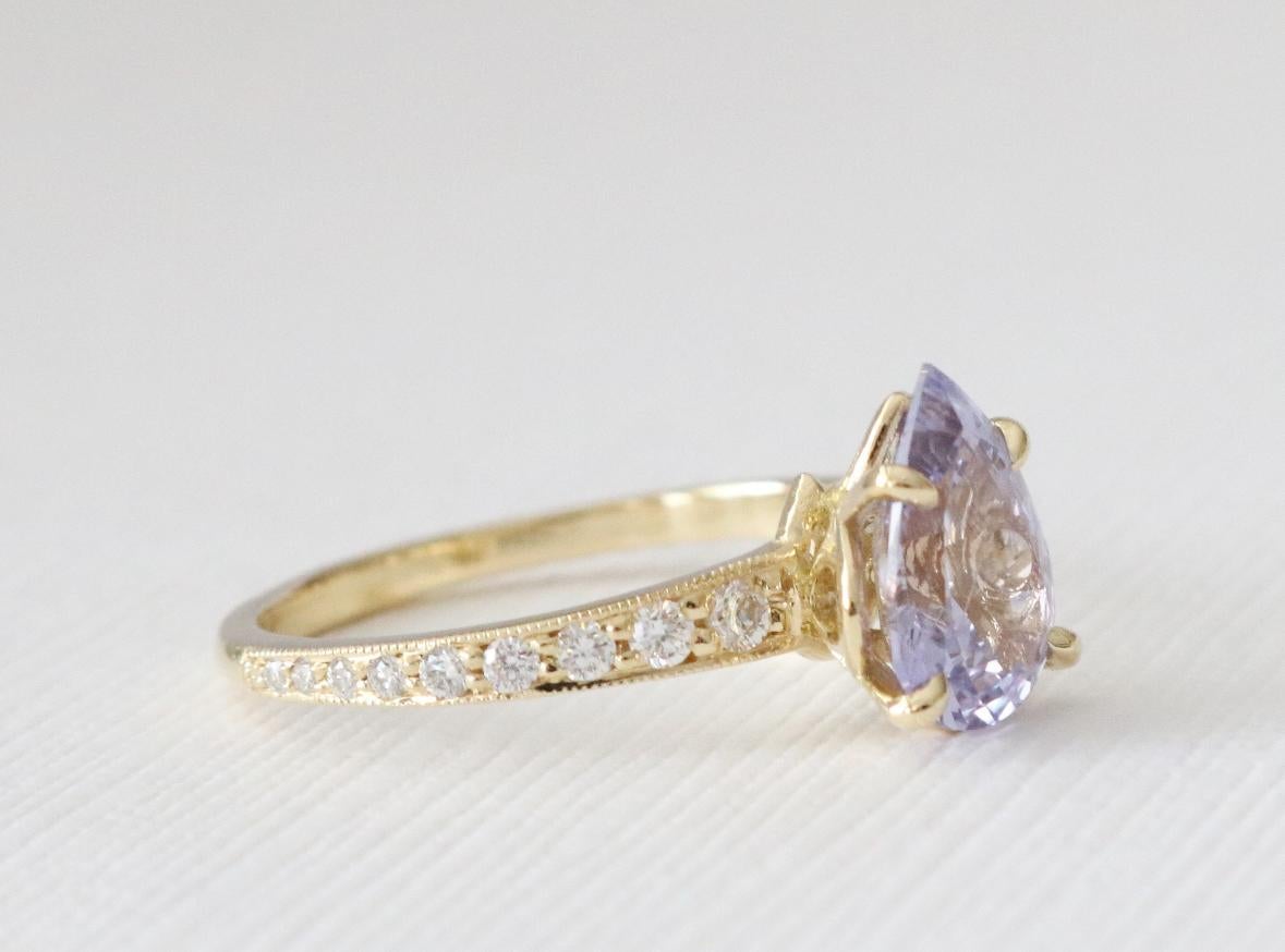 Discover the captivating beauty of this GIA Certified 1.66 Carats Natural Lavender Sapphire Engagement Ring—an exquisite declaration of love and sophistication. Crafted in opulent 18K yellow gold, the centerpiece features a pear brilliant-cut