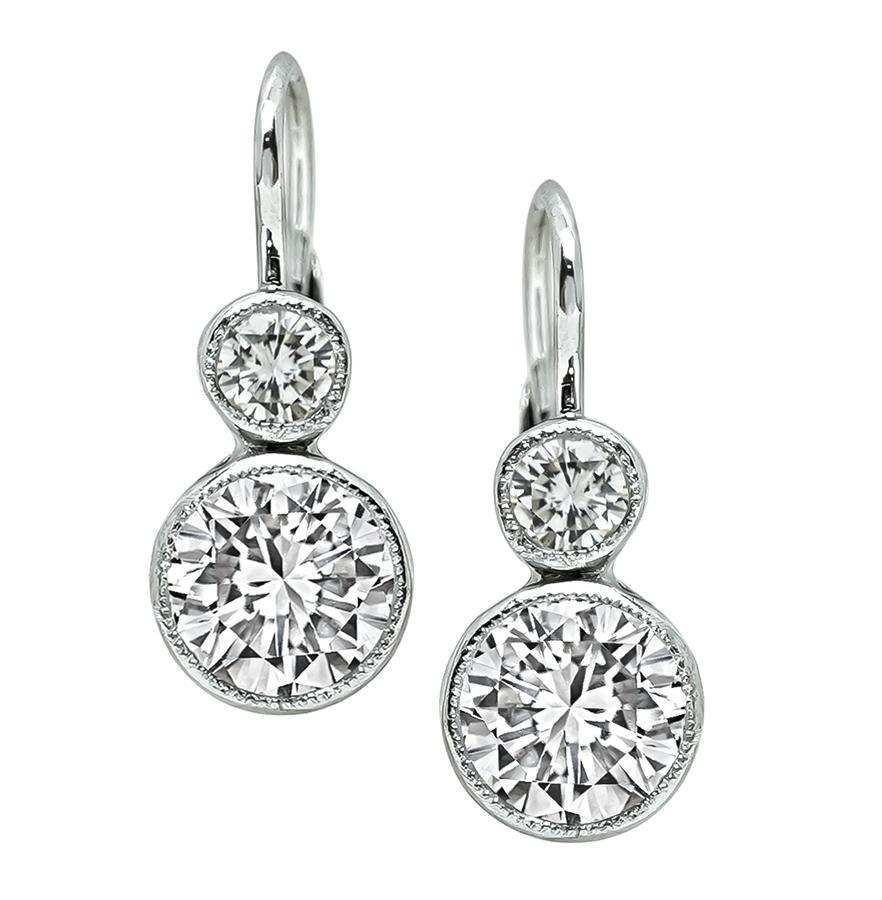 This is a stunning pair of platinum earrings. The earrings feature 2 sparkling GIA certified round cut diamonds that weigh 0.82ct and 0.86ct. The color of the diamonds is E with VS2 clarity and F with VS2 clarity. The 2 diamonds are accentuated by 2