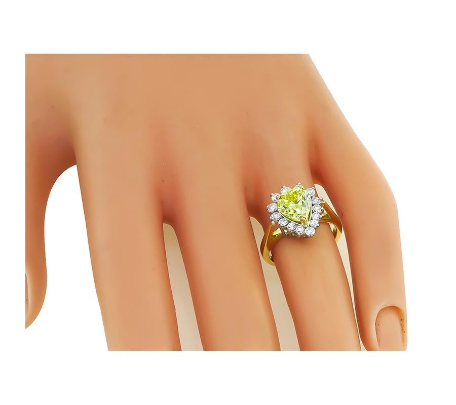 This is an amazing 18k yellow and white gold engagement ring. The ring is centered with a sparkling GIA certified pear shape natural fancy yellow diamond that weighs 1.68ct. The color of the diamond is Even Intense Yellow with VS1 clarity. The