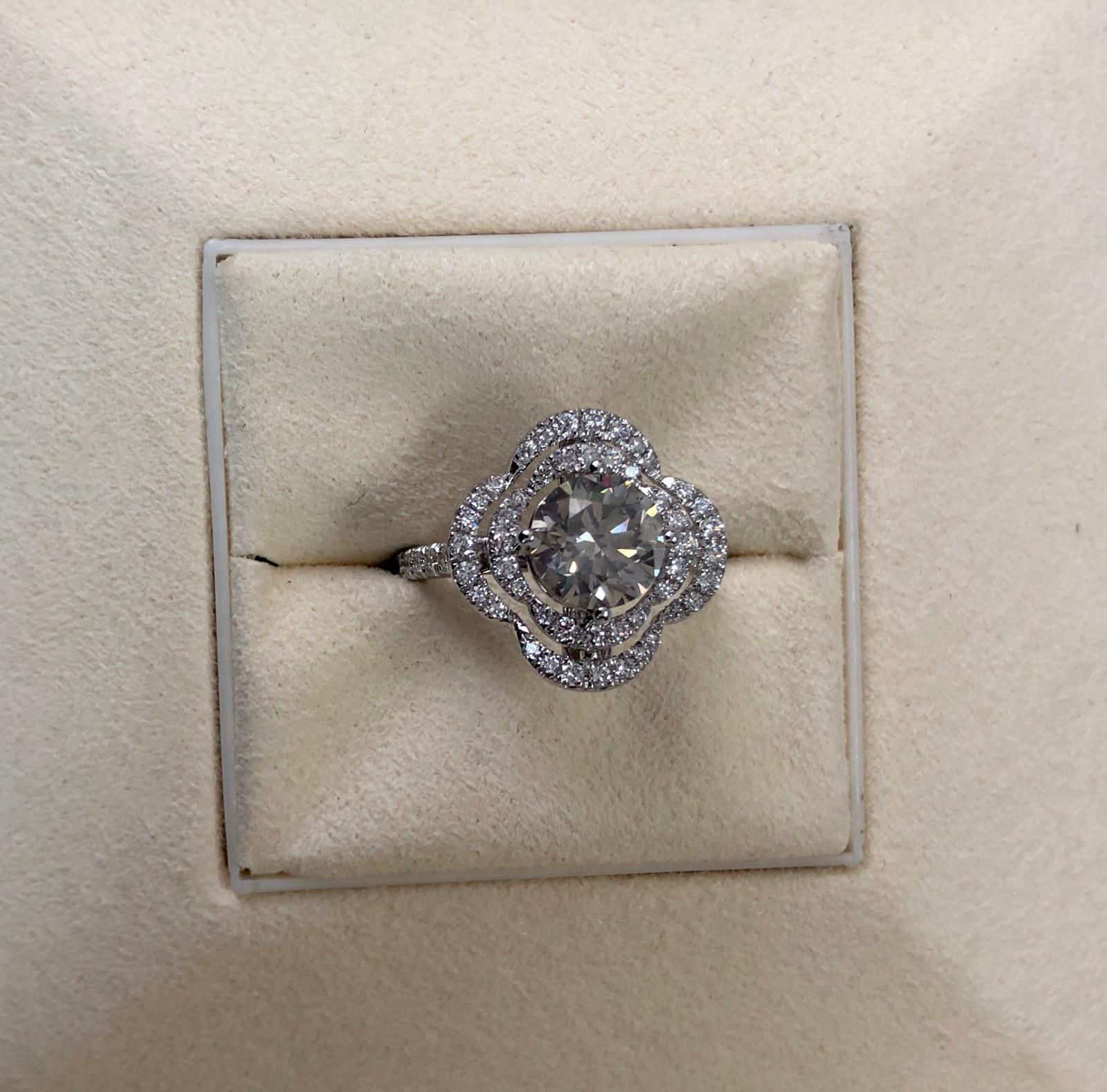 This is a fancy dark gray round natural diamond weighing 1.70 carats. surrounded by paved white diamonds in the flower shaped halo setting. Its transparency and luster are excellent. set on 18 karat white gold, this ring is the ultimate gift for