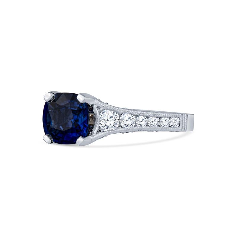 This exquisite ring features a captivating 1.74 carat cushion cut blue sapphire sourced from Sri Lanka, elegantly set in 18 karat white gold. Adorned with 38 sparkling round diamonds totaling 0.47 carats, this piece exemplifies refined beauty and