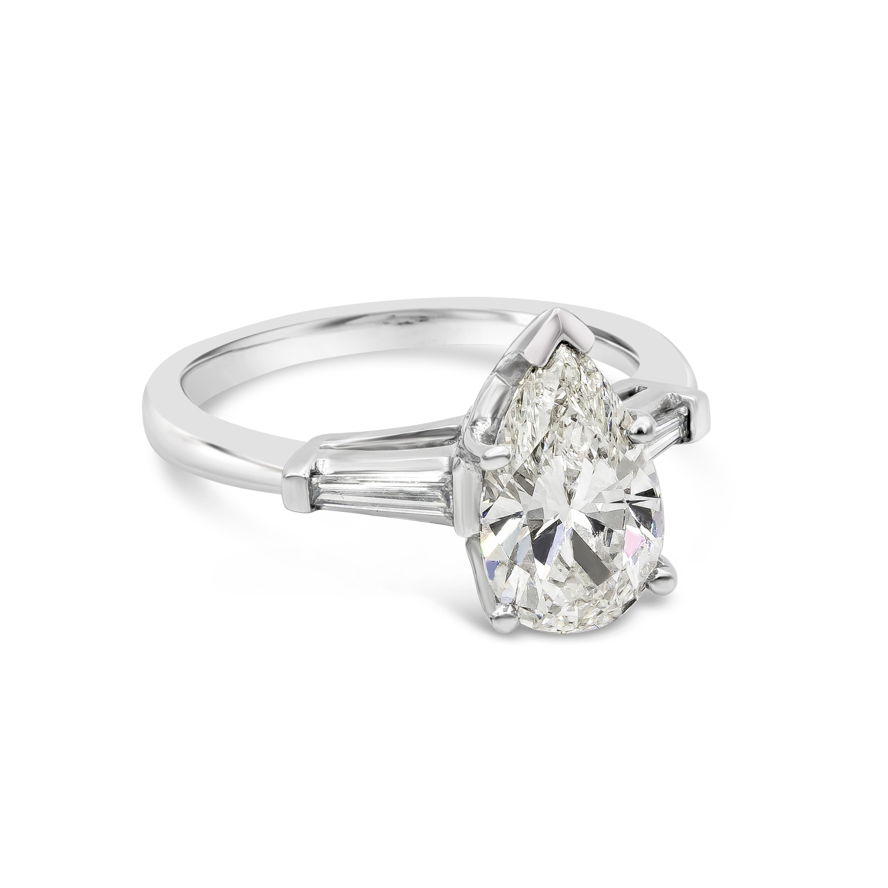 A classy and elegant three stone engagement ring style showcasing a 1.74 carats pear shape diamond center stone certified by GIA as I color, VS2 clarity. Flanking on each side are two tapered baguette cut diamonds, set in a platinum mounting. Size