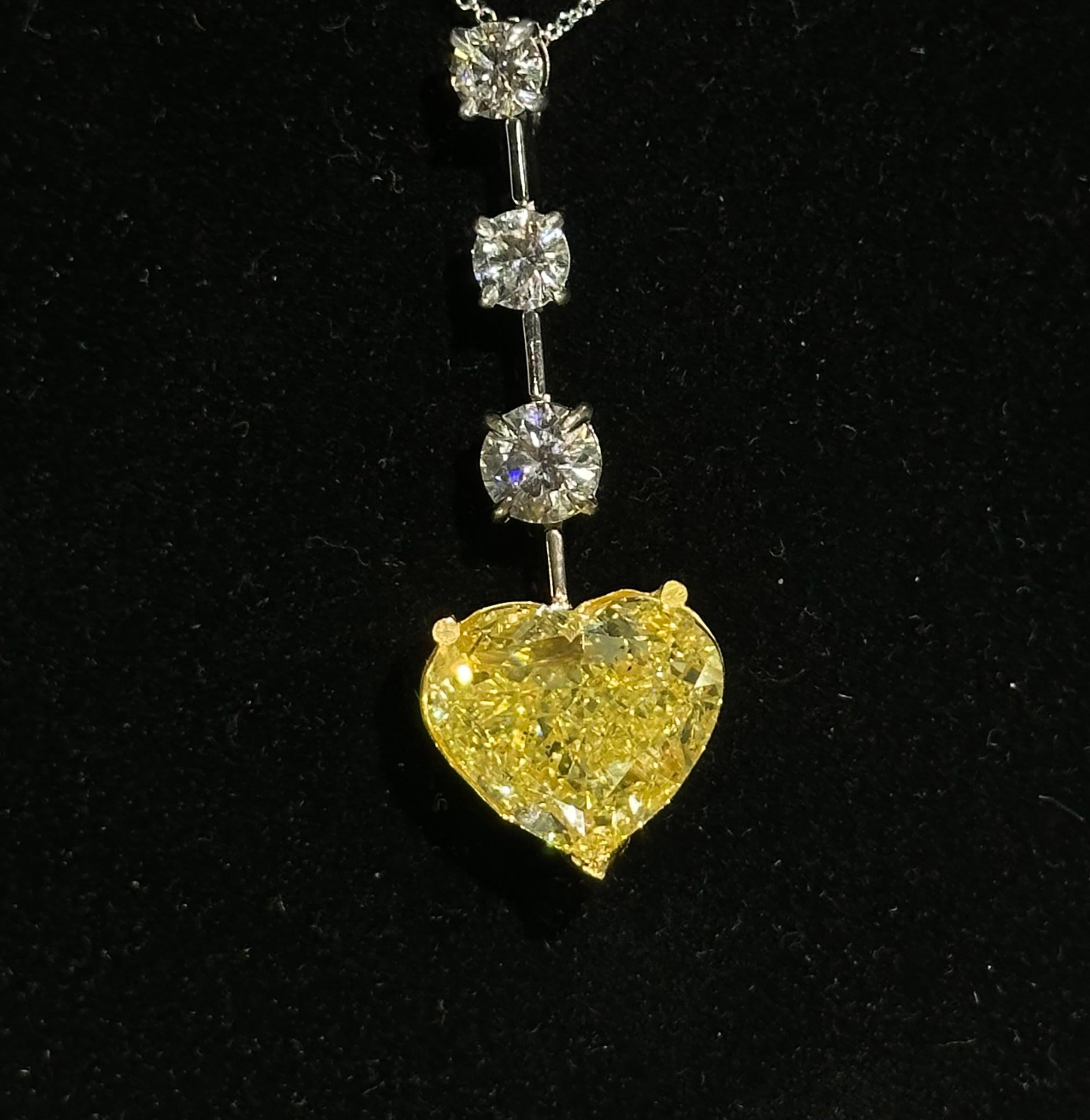 Absolutely stunning, Ladies 18 karat white and yellow gold 17.70 carat total weight GIA Certified diamond necklace features a whooping 14.04 carat natural fancy yellow modified brilliant cut heart shaped diamond in the center. The very large heart