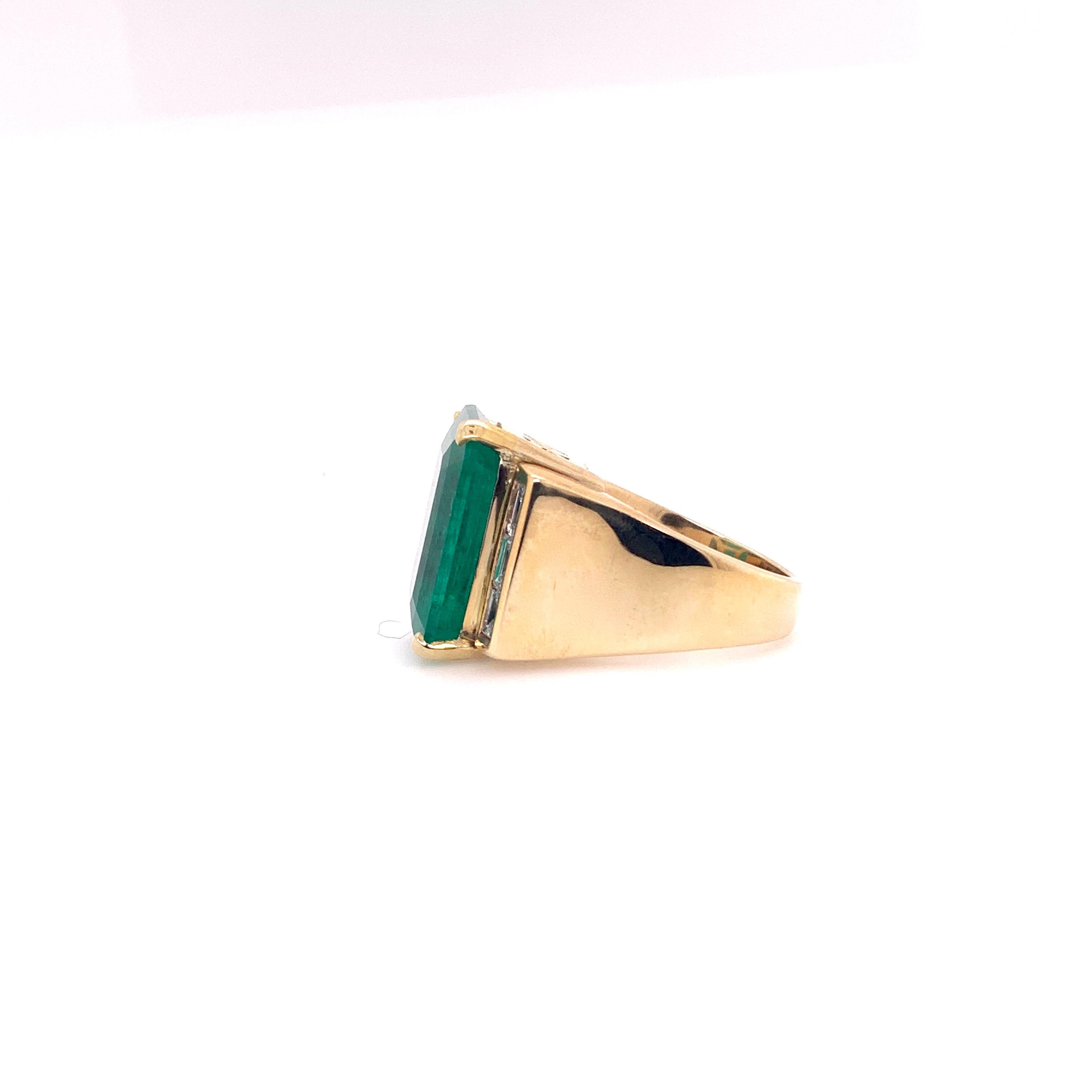 This gigantic GIA certified Columbian Emerald weights 18.07 cts and is set in a 14k yellow gold handmade setting.   The 3 vertical straight diamond baguettes are channel set on each side of the emerald in this heavy, bold yellow gold setting.   This