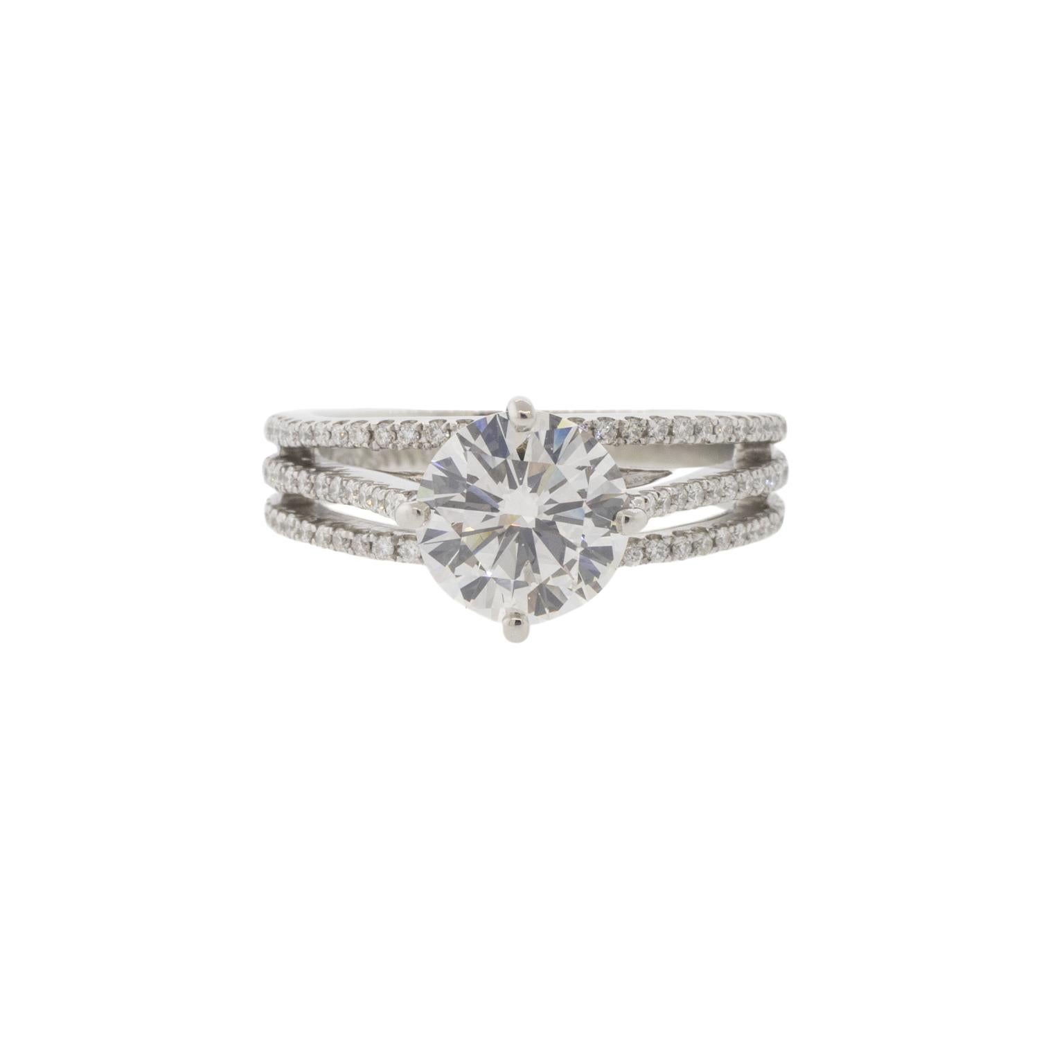 An absolute stunner, this split shank engagement ring has three bands adorned with diamonds. The center stone is a GIA certified 1.80ct I/VS2 natural round brilliant cut diamond. There are .60ctw of G-H/VS2-SI1 round brilliant natural diamonds