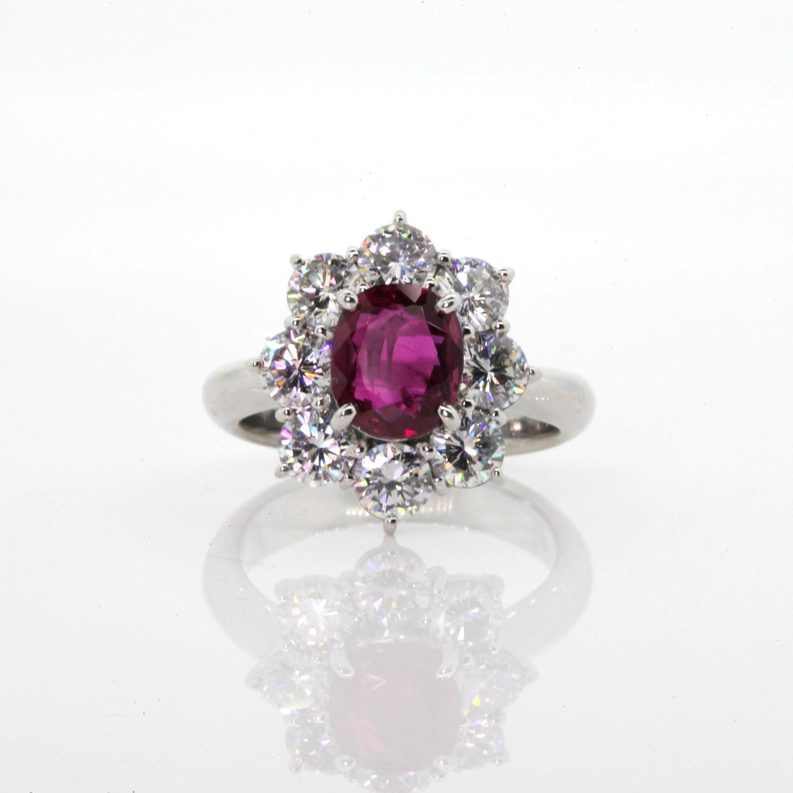 A beautiful platinum cluster ring centering a 1.82 carat G.I.A. certified Cushion cut Red Ruby.  The Ruby of Thai origins is surrounded by eight fiery Round Brilliant Cut Diamonds all weighing 1,89 carat of H color - VS clarity.  A Most Impressive!