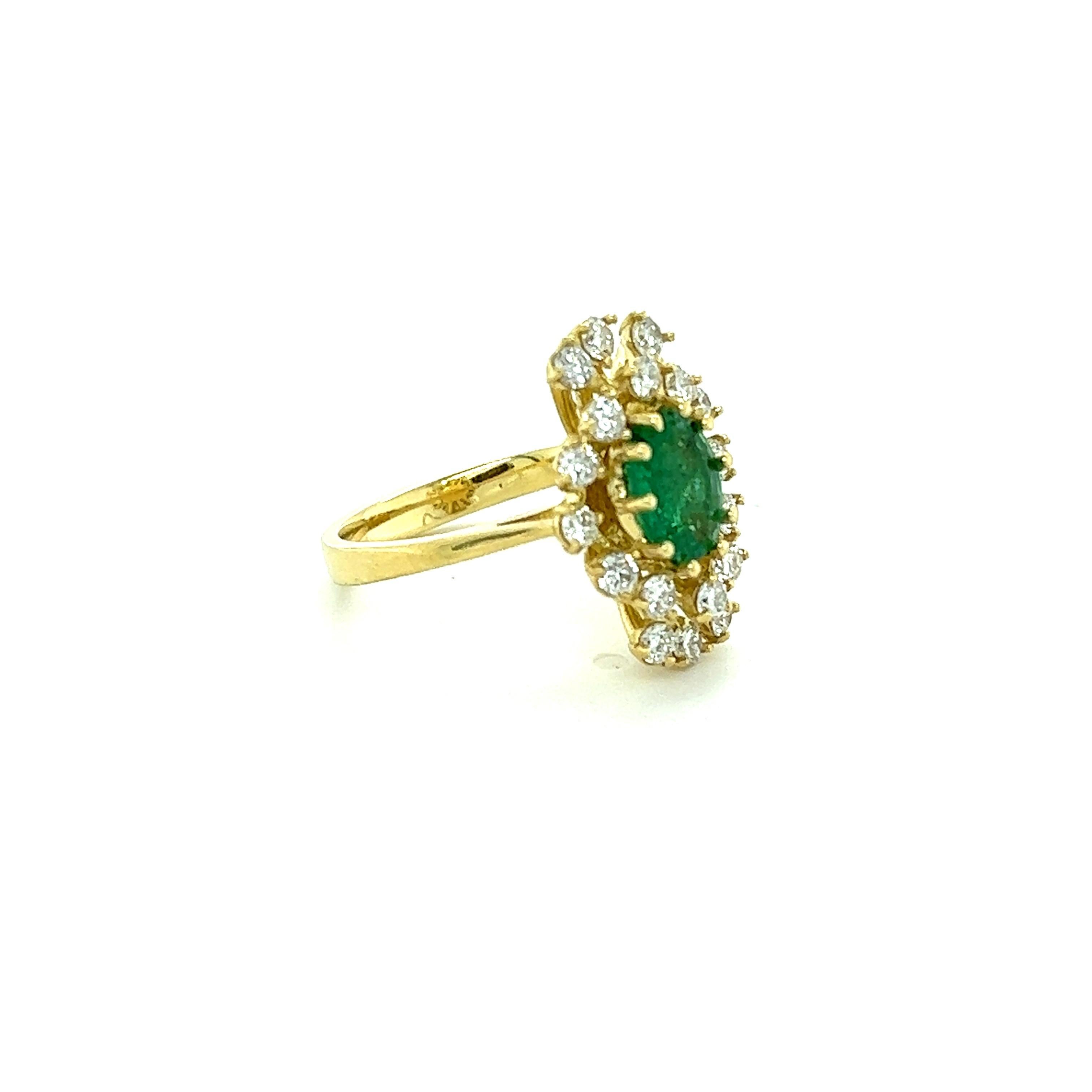 This ring has a 1.03 Carat Oval Cut Emerald and is surrounded by 18 Round Cut Diamonds that weighs 0.84 Carats. (Clarity: SI1, Color: F) The total carat weight of the ring is 1.87 carats. 
The Oval Cut Emerald measures at approximately 8 mm x 6 mm.
