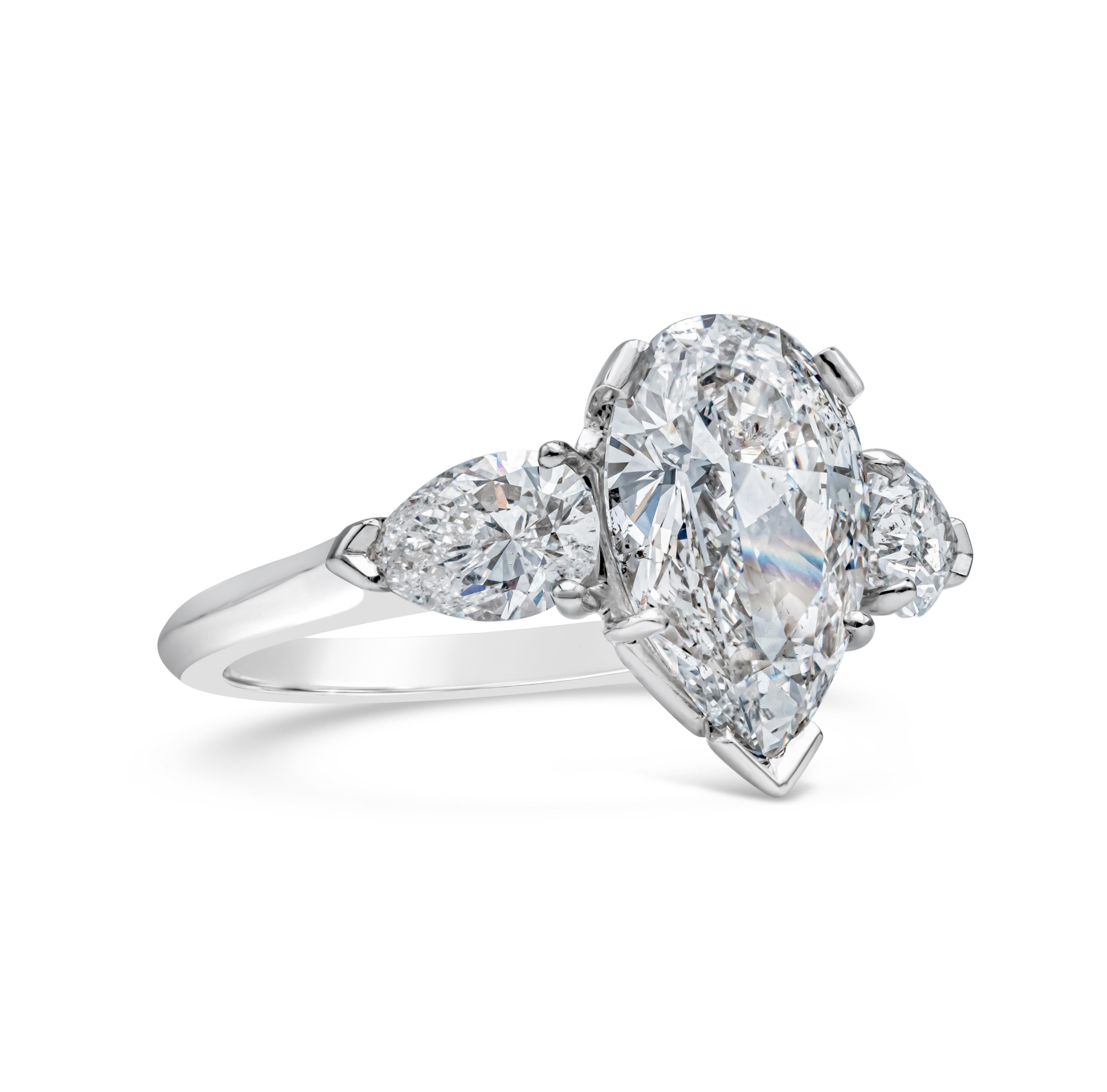 A chic three-stone engagement ring style, showcasing a 1.88 carats pear shape diamond certified by GIA as F color and SI2 clarity, set on a five prong setting. Flanked by two melee pear shape diamonds weighing 0.91 carat total. Set on a polished
