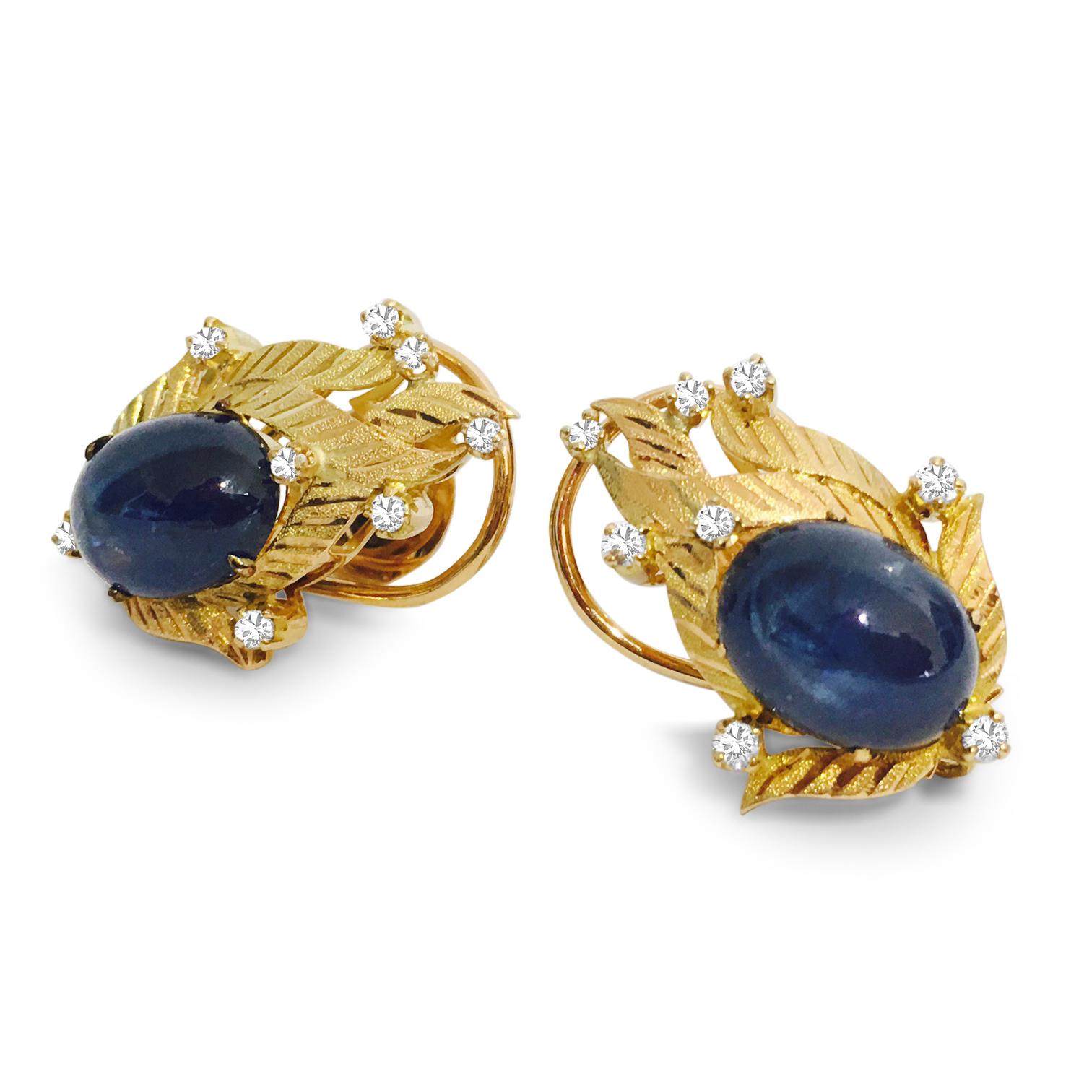 Indulge in the opulence of these vintage diamond and blue sapphire earrings, crafted from luxurious 18K yellow gold. The focal point of each earring is a breathtaking 14.50 carat natural earth-mined blue sapphire, boasting a cabochon cut with vivid