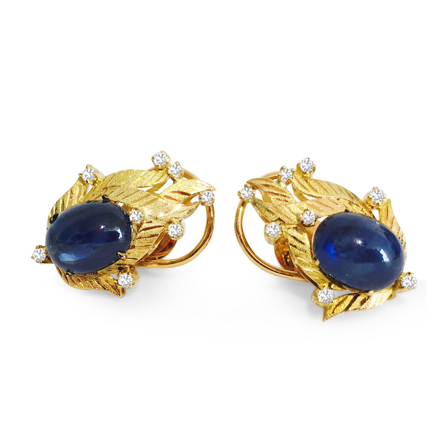 Indulge in the opulence of these vintage diamond and blue sapphire earrings, crafted from luxurious 18K yellow gold. The focal point of each earring is a breathtaking 14.50 carat natural earth-mined blue sapphire, boasting a cabochon cut with vivid