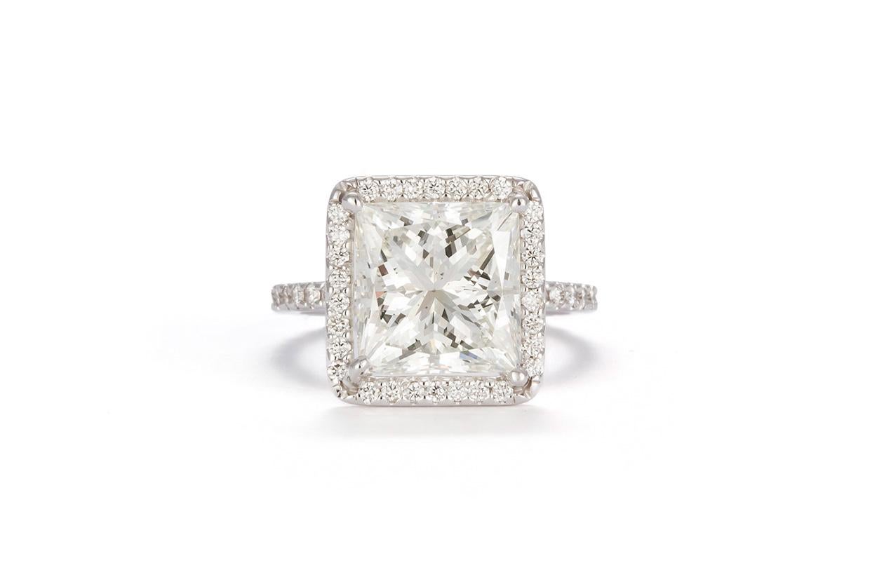 We are pleased to offer this GIA Certified 18K White Gold & Princess Cut Diamond Halo Engagement Ring. This beautiful ring features a GIA certified inscribed 5.59ct J/VS2 princess cut diamond set in a 18k White Gold 4 prong halo setting. The diamond