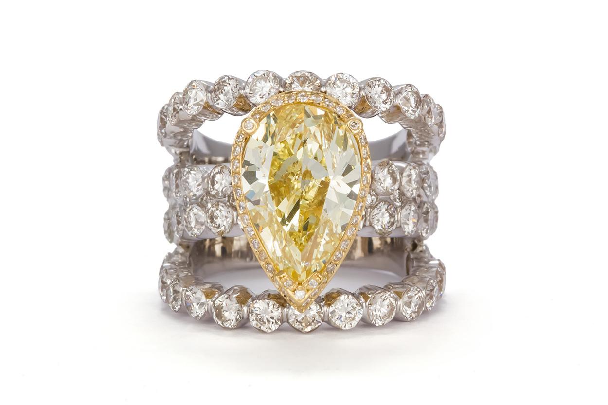 We are pleased to offer this GIA Certified and Laser Inscribed Natural Fancy Yellow Pear Cut Diamond Ring 9.50ctw. This stunning ring features a GIA certified 5.01ct SI1 natural fancy yellow pear cut diamond accented beautifully by an estimated