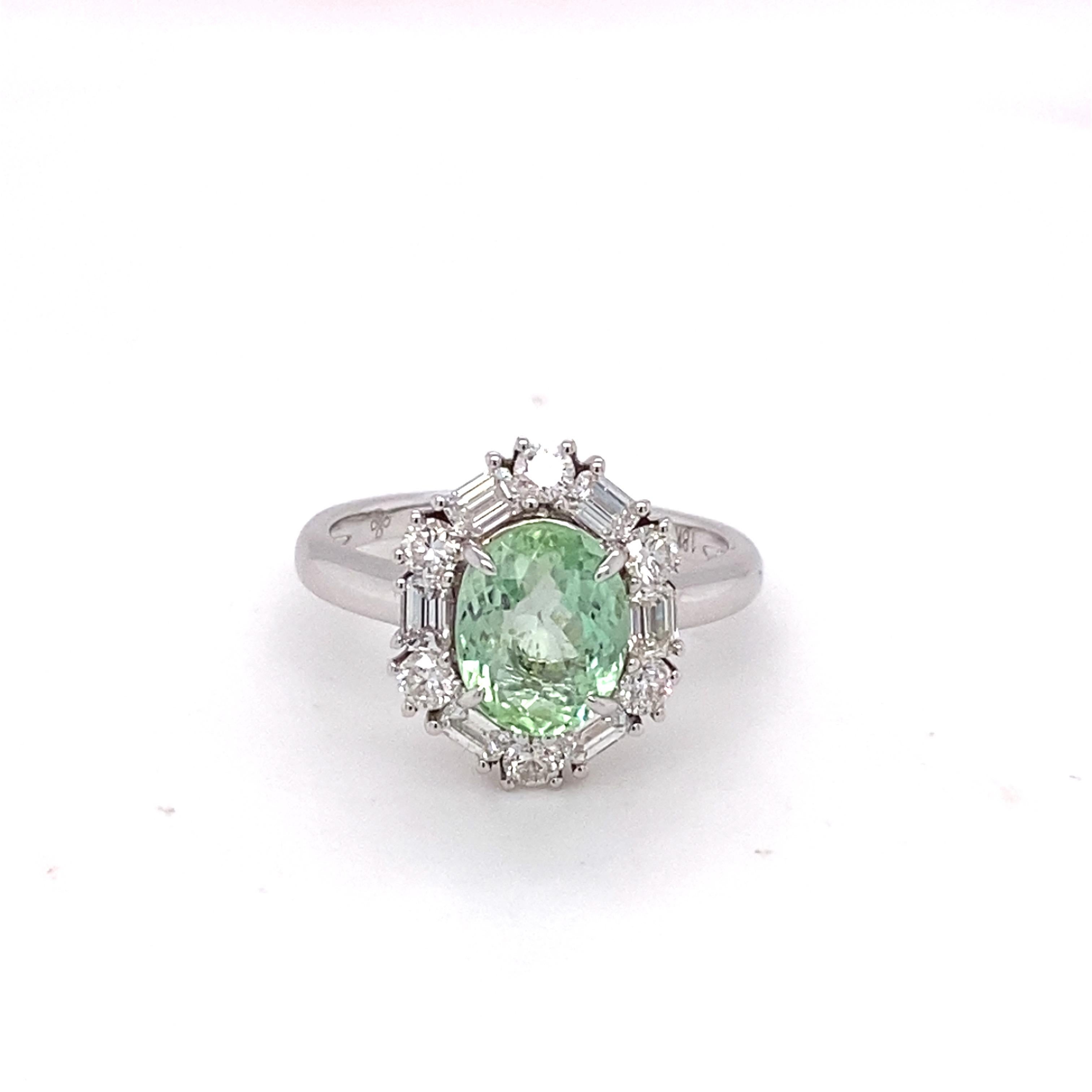 Inspired by modern glamor, this ring features a Paraiba color tourmaline. Oval shaped gemstone is framed by a halo of baguette and round diamonds. This one of a kind ring symbolizes luxury and grace. Meticulously crafted in 18K white gold. 
Weight