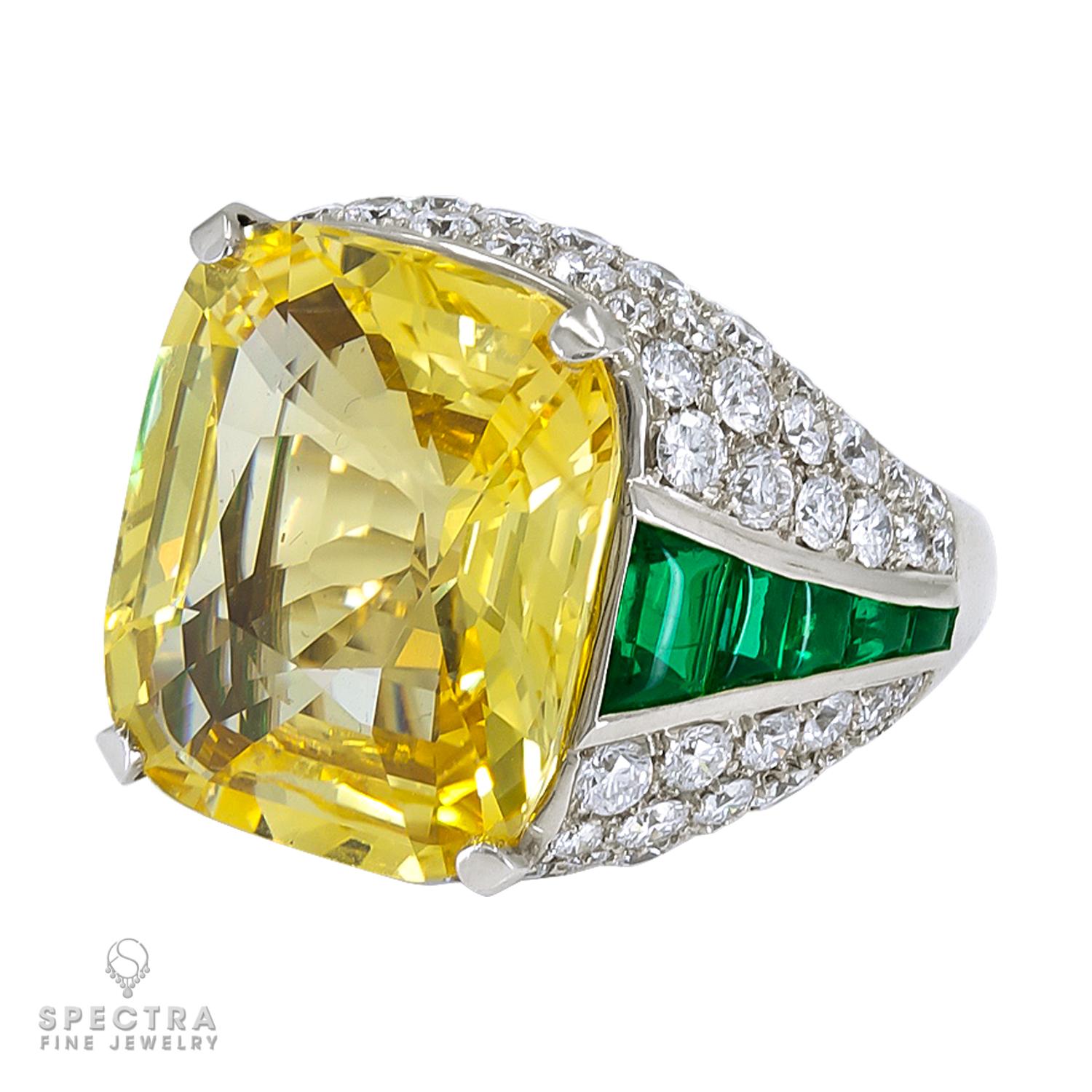 This breathtaking ring showcases a magnificent cushion-cut yellow sapphire, weighing 19.06 carats, set within a sparkling circular-cut diamond surround. The vibrant yellow hue of the sapphire is complemented by the brilliance of the diamonds,