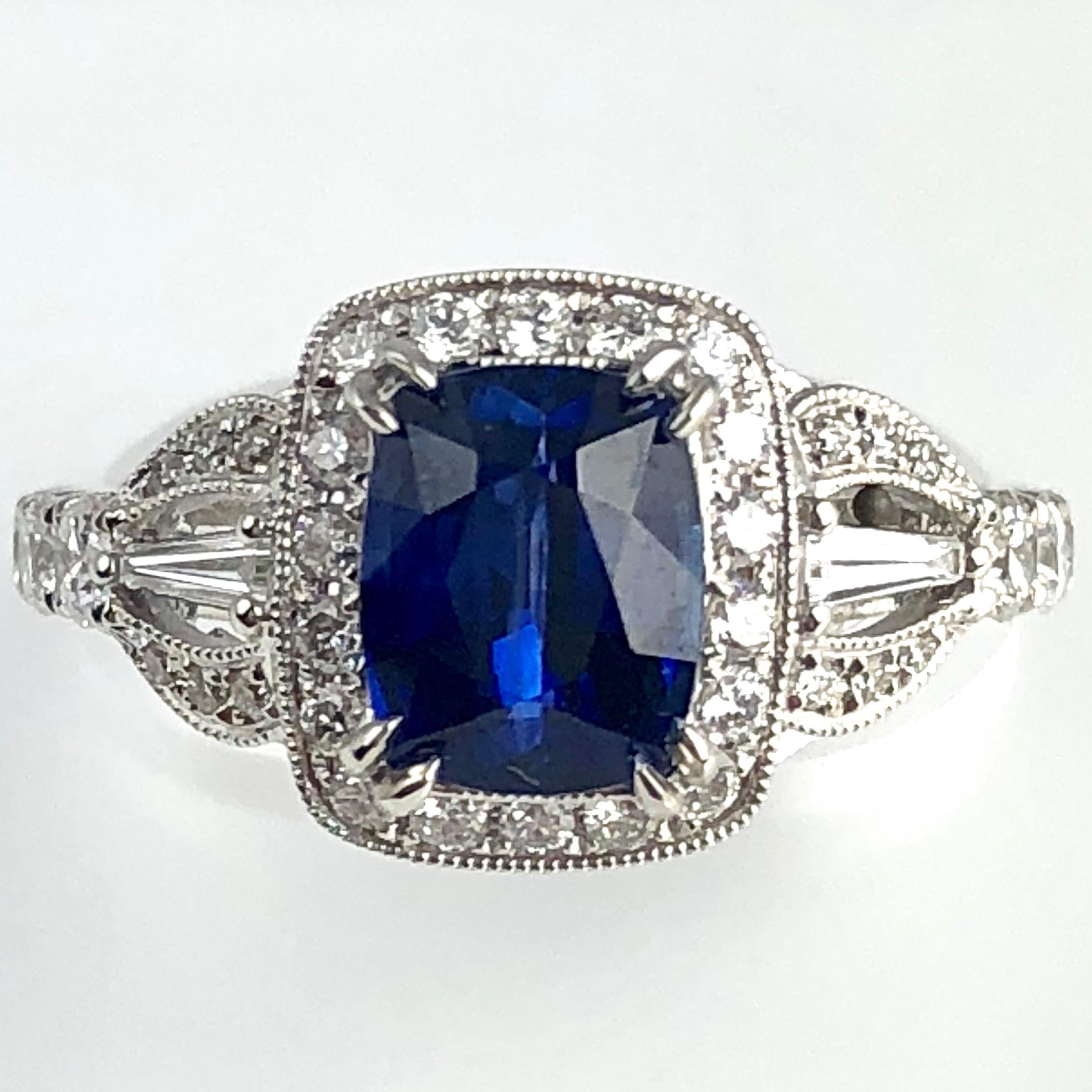 (DiamondTown) With a GIA Certified 1.93 carat cushion cut fine Ceylon sapphire center, and 0.81 carats white diamonds, this ring shines from every angle. Intricate hand engraved milgrain work throughout adds to the charm of the piece.

GIA