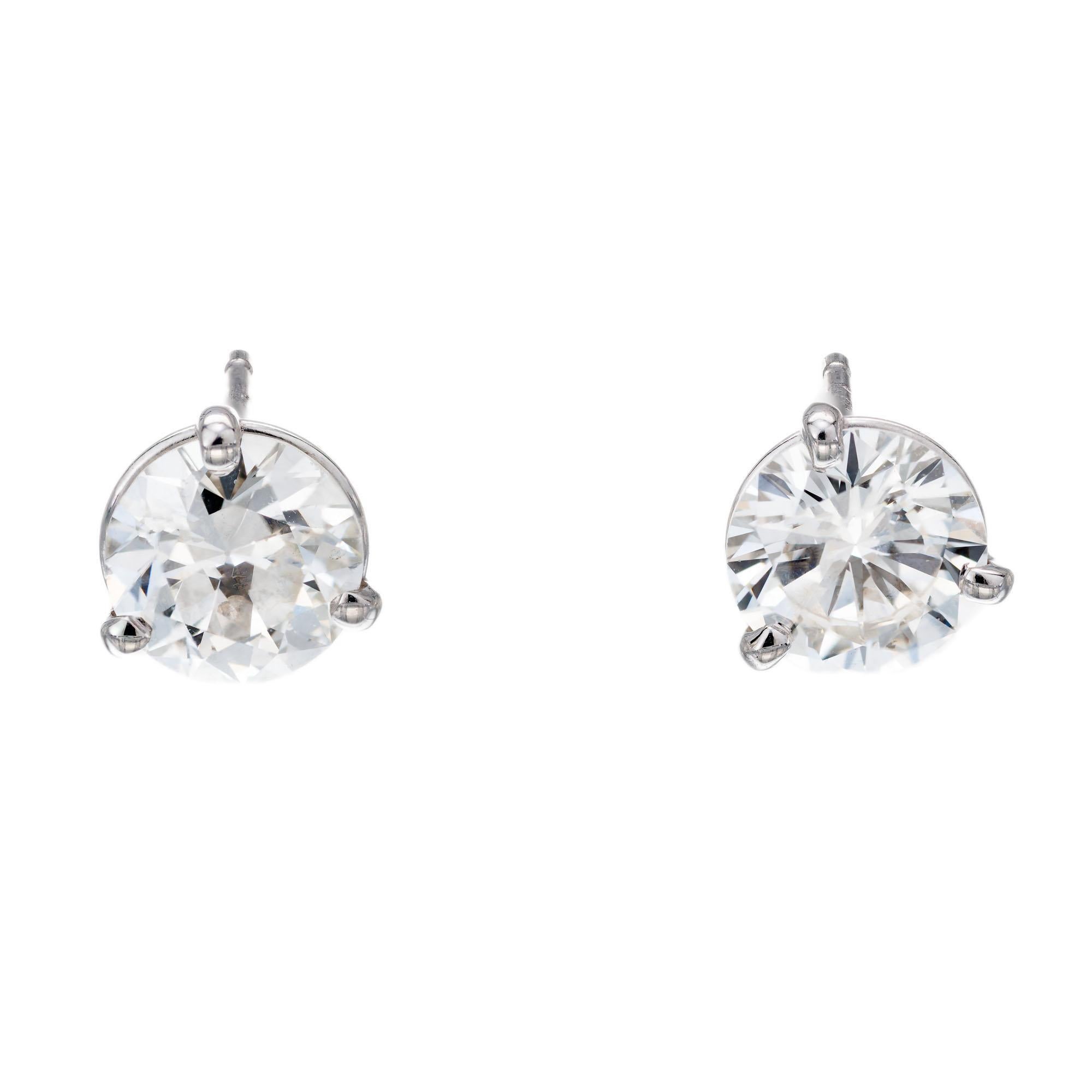 Round diamond stud earrings in two three-prong platinum basket settings. CIA certified. 

1 round diamond, approx total weight: .98cts I, SI1 GIA Certified.  GIA certified# 5172585703
1 round diamond, approx total weight: .96cts H, VS1, GIA