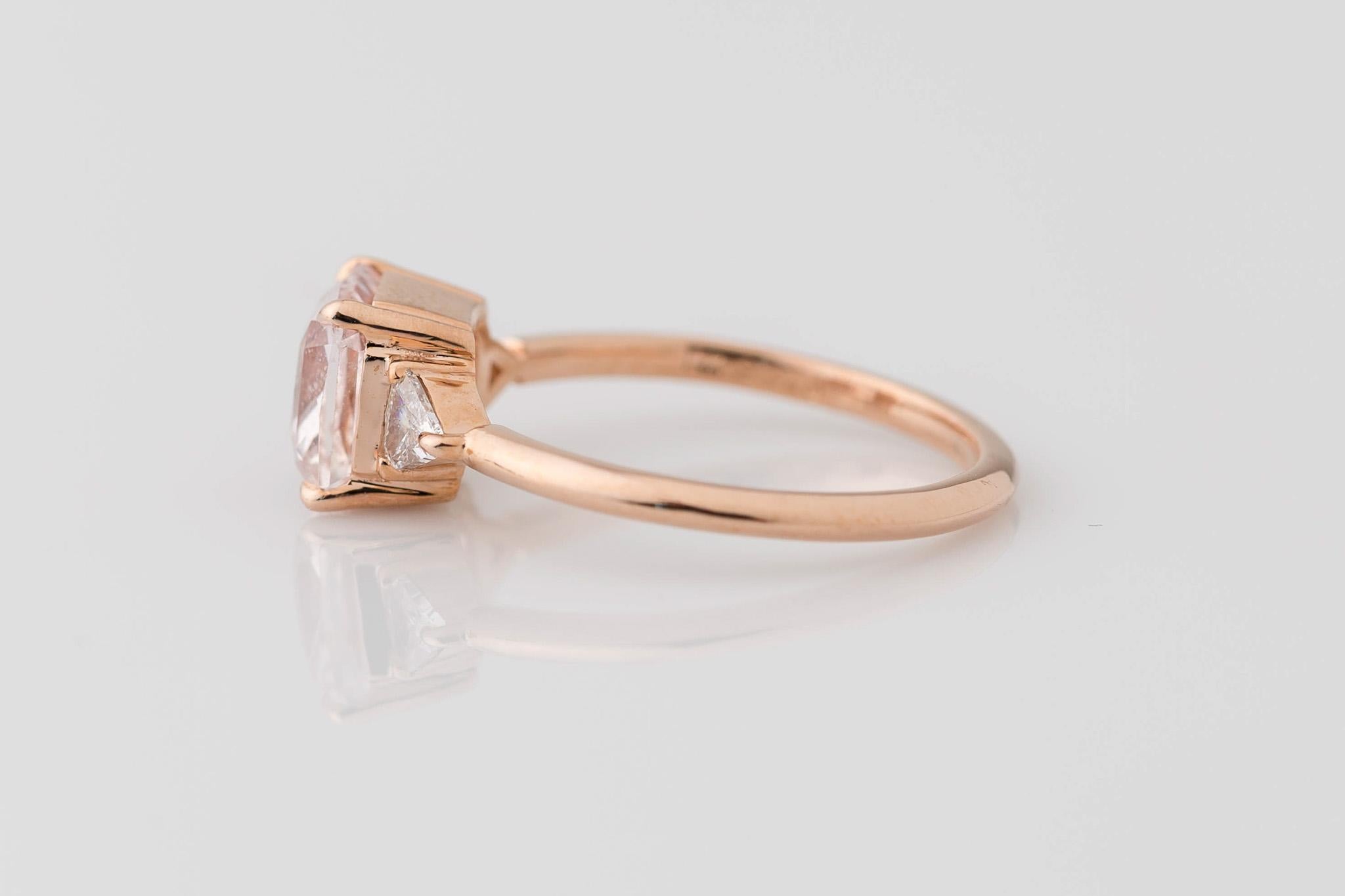 Step into elegance with our GIA Certified 1.98 Ct. Radiant Cut Pink Sapphire Ring. At its heart lies a radiant-cut natural no-heat sapphire, 1.98 carats, transparently pale pink, measuring 6.97x6.78x4.15mm. Framing the center stone are two