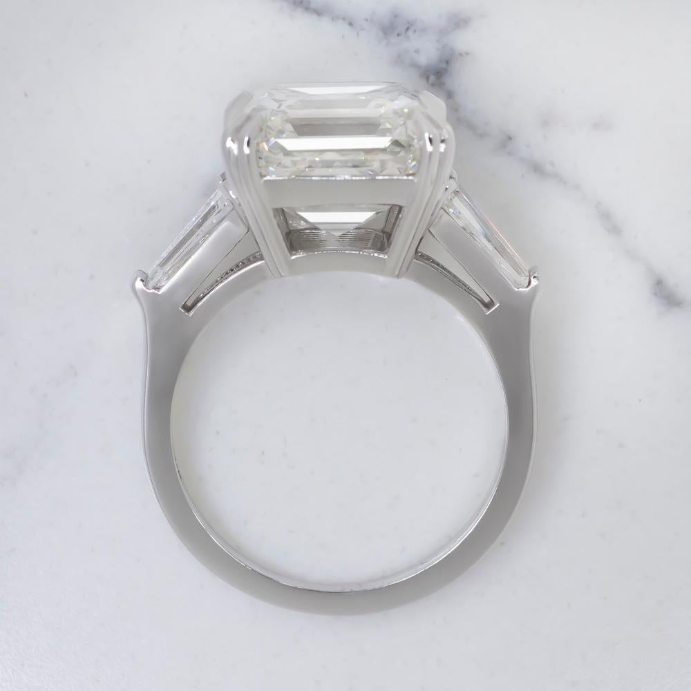 An exquisite ring composed by a main 3 carat asscher cut diamond j in color vvs2 in clarity 
the side diamonds are tapered baguettes 
the ring is set in 18 carats white gold