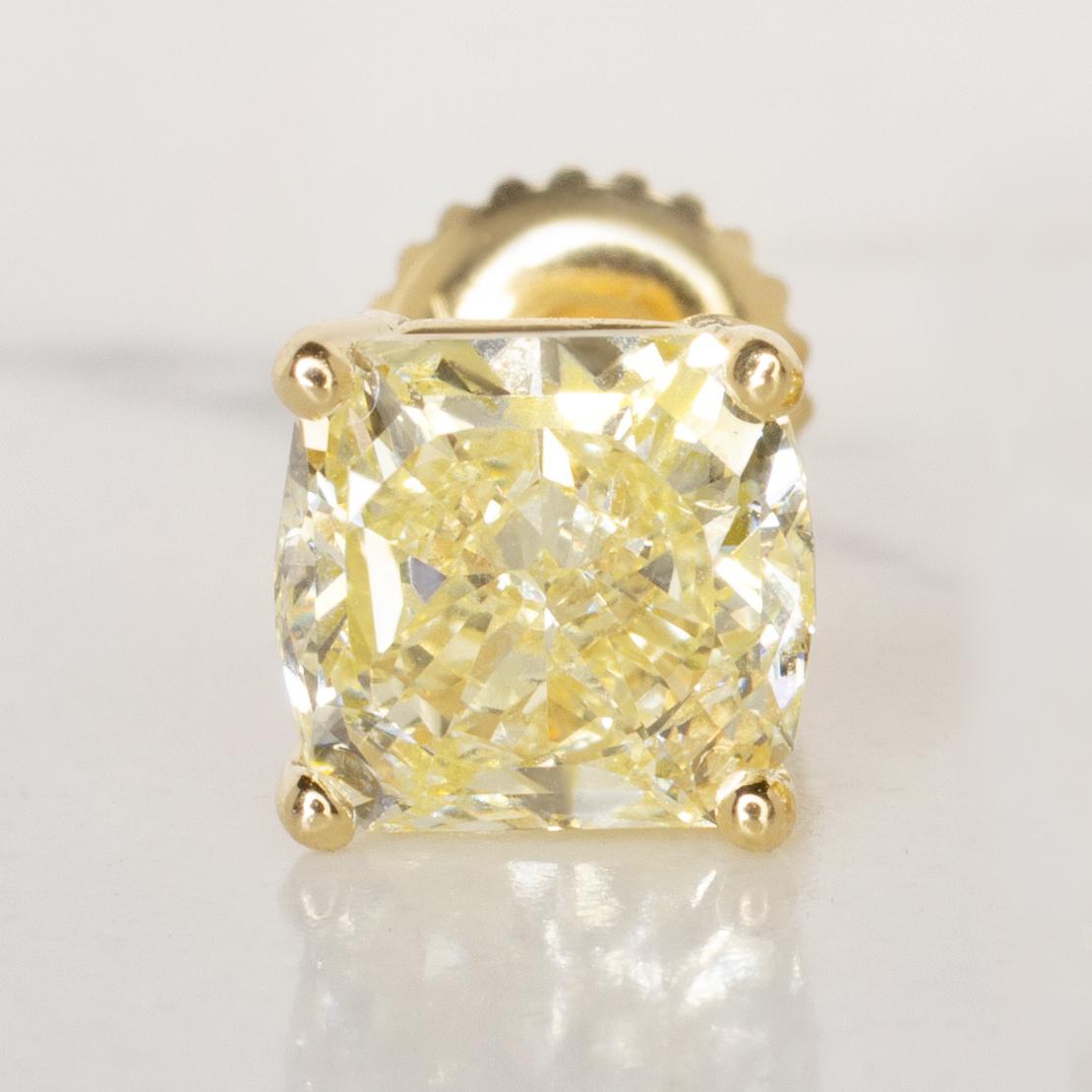 These are GIA Certified 2 Carat cushion cut fancy yellow, internally flawless diamond stud earrings set in yellow gold. 

Cushion cut diamonds blend the energy of a round brilliant with the symmetry of a radiant cut, a combination that maximizes the