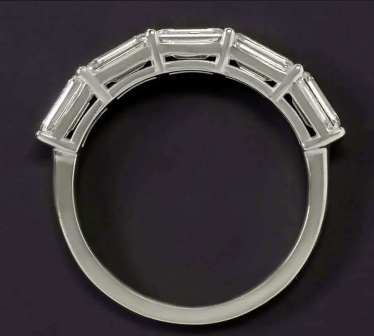 Dieser exquisite Ehering ist eine raffinierte und moderne Interpretation eines klassischen Designs mit fünf perfekt aufeinander abgestimmten Diamanten im Smaragdschliff, die in einer schlanken Ost-West-Ausrichtung gefasst sind. Mit insgesamt 2,09