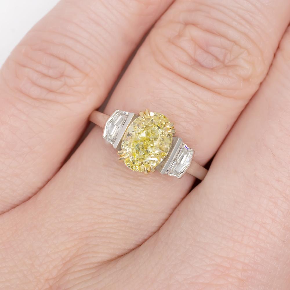 An exquisite three stone fancy yellow oval diamond certified by GIA 

The main diamond has been certified as vvs1 clarity 

The ring has been handmade in Italy