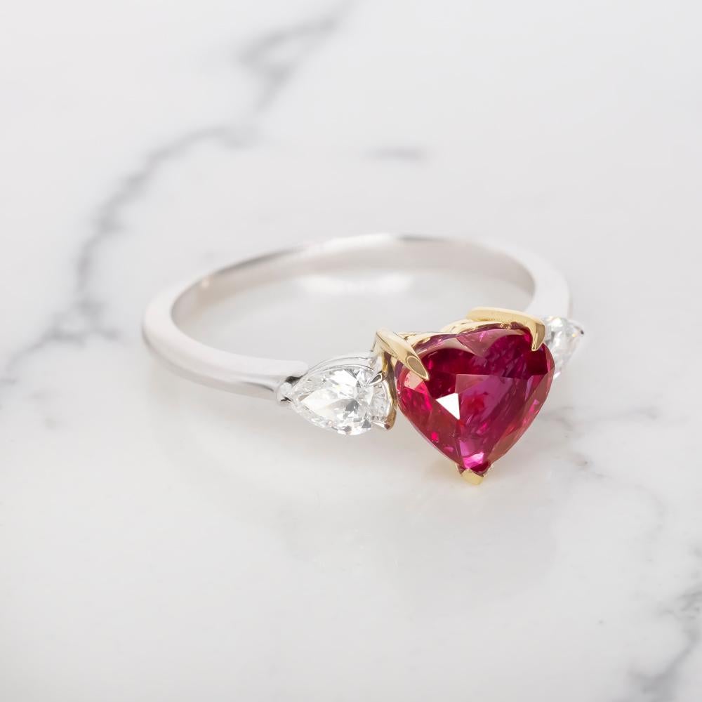 our breathtaking GIA certified 2 carat heart-shaped vivid red corundum ruby cocktail ring. Crafted with precision and passion, this masterpiece is nestled in solid 18k white and yellow gold, exuding timeless beauty.

At its center, a mesmerizing