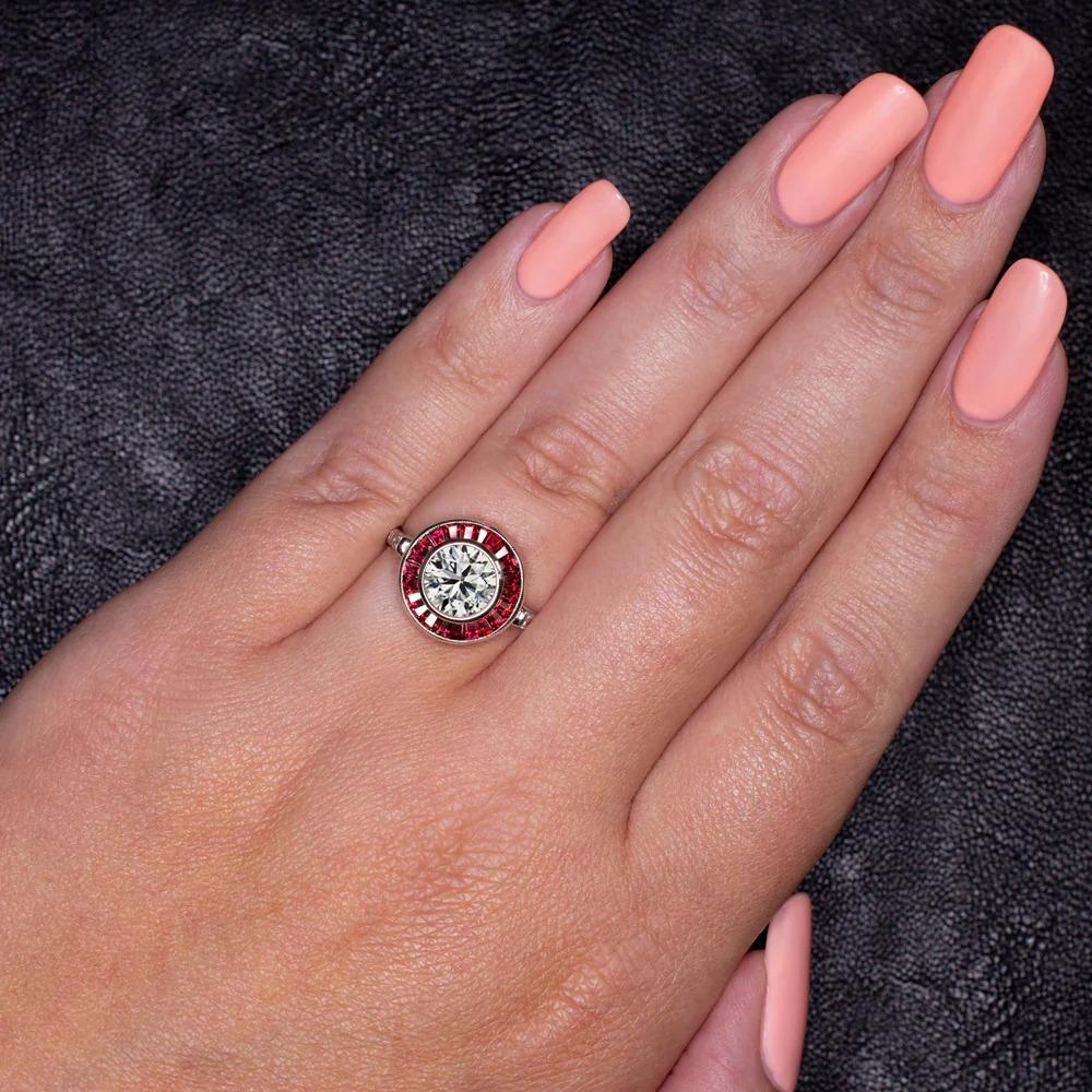 An exquisite Art Deco style ring features a lively and substantial 2.01ct diamond surrounded by a glamorous ring of rich red natural rubies. Certified by GIA with Very Good and Excellent grades in all finishing categories, the diamond has fantastic