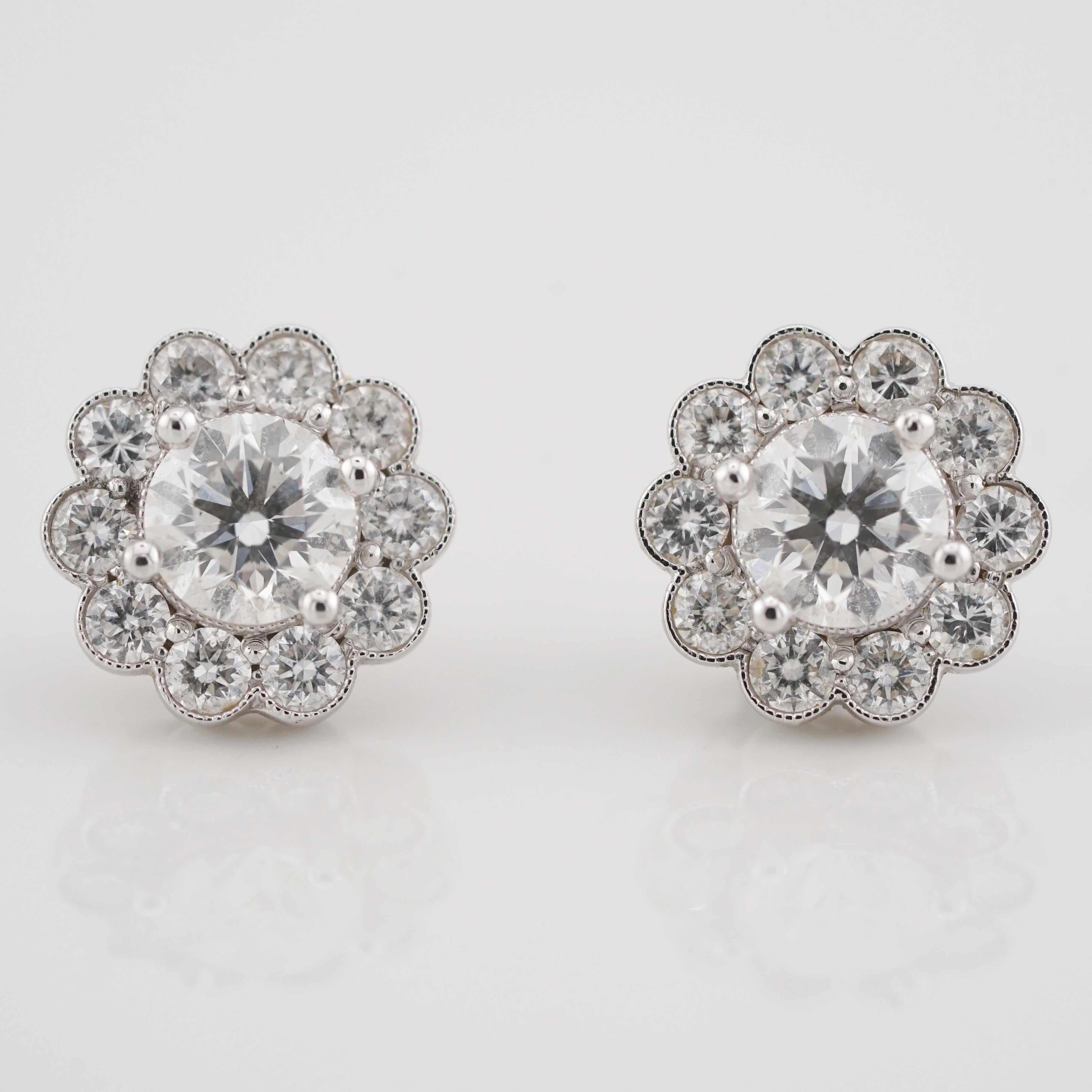 These elegant stud earrings feature two brilliant round-cut center diamonds with a combined total weight of 2 carats, GIA certified for their exceptional quality (F color, VS2 clarity). 

Each diamond is beautifully set at the heart of a scalloped