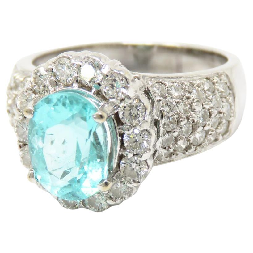 Experience unparalleled luxury with this exquisite ring, featuring a stunning tourmaline centerpiece as certified by GIA, measuring 9.91 x 7.47 x 5.55mm and weighing approximately 2.6 carats. Surrounding the tourmaline are 52 natural diamonds,