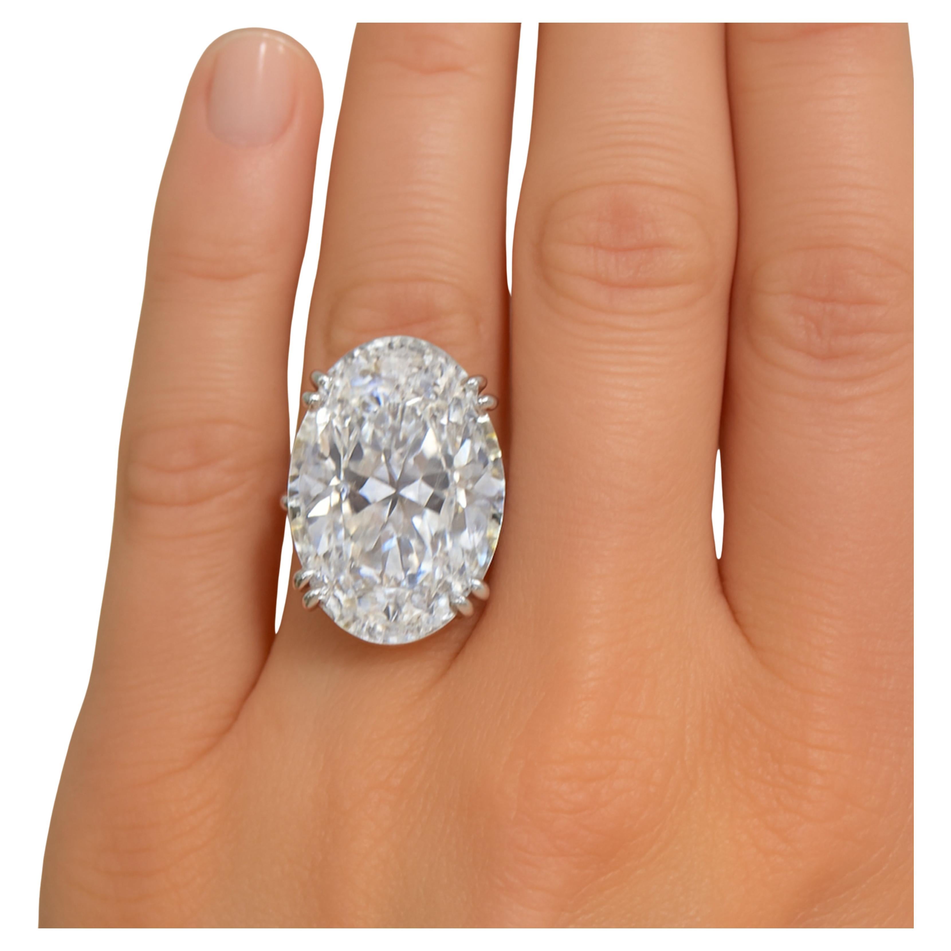Questo splendido anello certificato GIA ha come centro un notevole diamante di 20 carati dal taglio ovale, avvolto in un'elegante incastonatura a pavé che ne esalta la brillantezza. 
Realizzato in oro bianco 18 carati, il design dell'anello emana