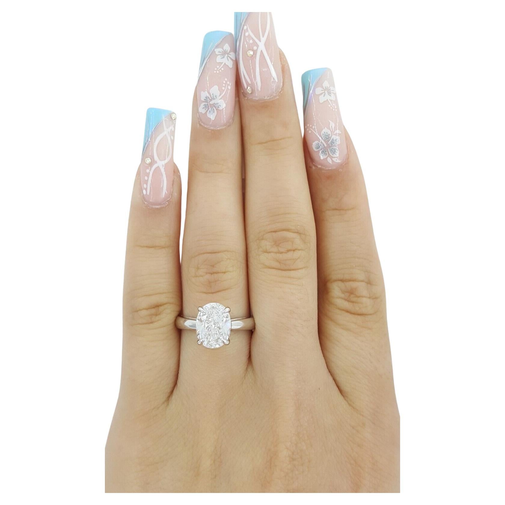 This refined solitaire engagement ring features a GIA certified 2.01 carat oval cut diamond set in a sleek platinum band. 

The center stone displays an D color grade, offering exceptional whiteness and a bright, clean appearance. With a VS1 clarity