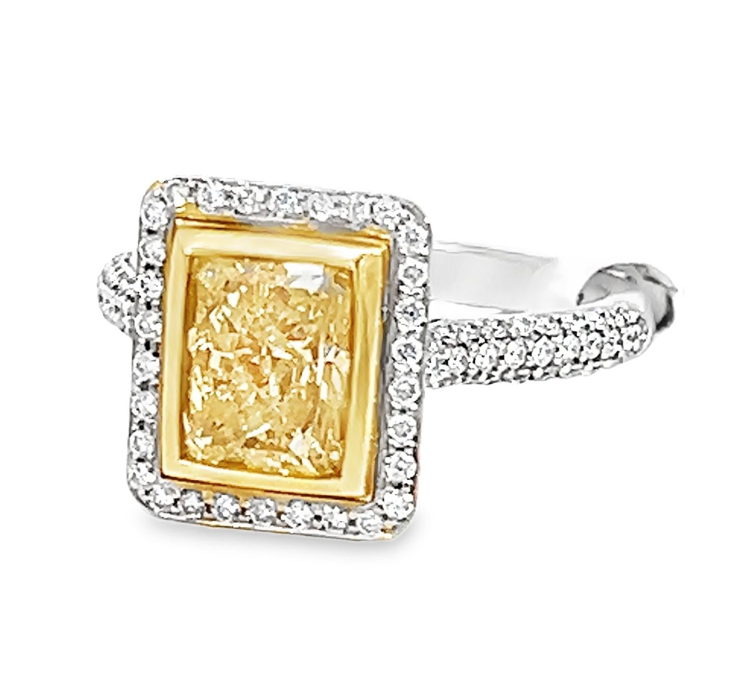 GIA-certified 18k white and yellow gold ring features a 2.00-carat Fancy Yellow radiant-cut diamond (GIA# 2155474296) with VS2 clarity and even color distribution. The modified rectangular mixed cut measures 7.59 x 6.05 x 4.37mm. 

The center