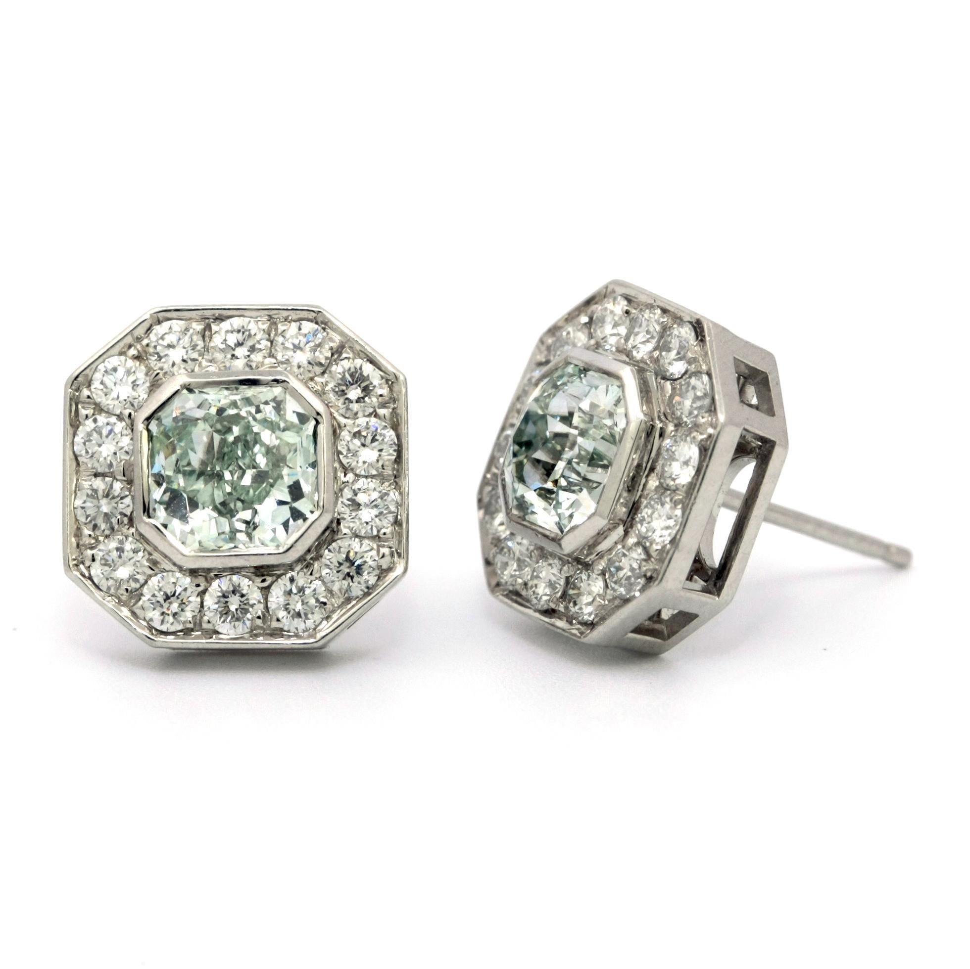 This remarkable platinum earrigns conssist of two center diamonds: 1.00ct Fancy Light Green Vs1 GIA and 1.00ct Fanct Light Green VS2 GIA. 
Each green center diamond is surrounded by 13 white round diamonds. total carat weight of white diamonds is