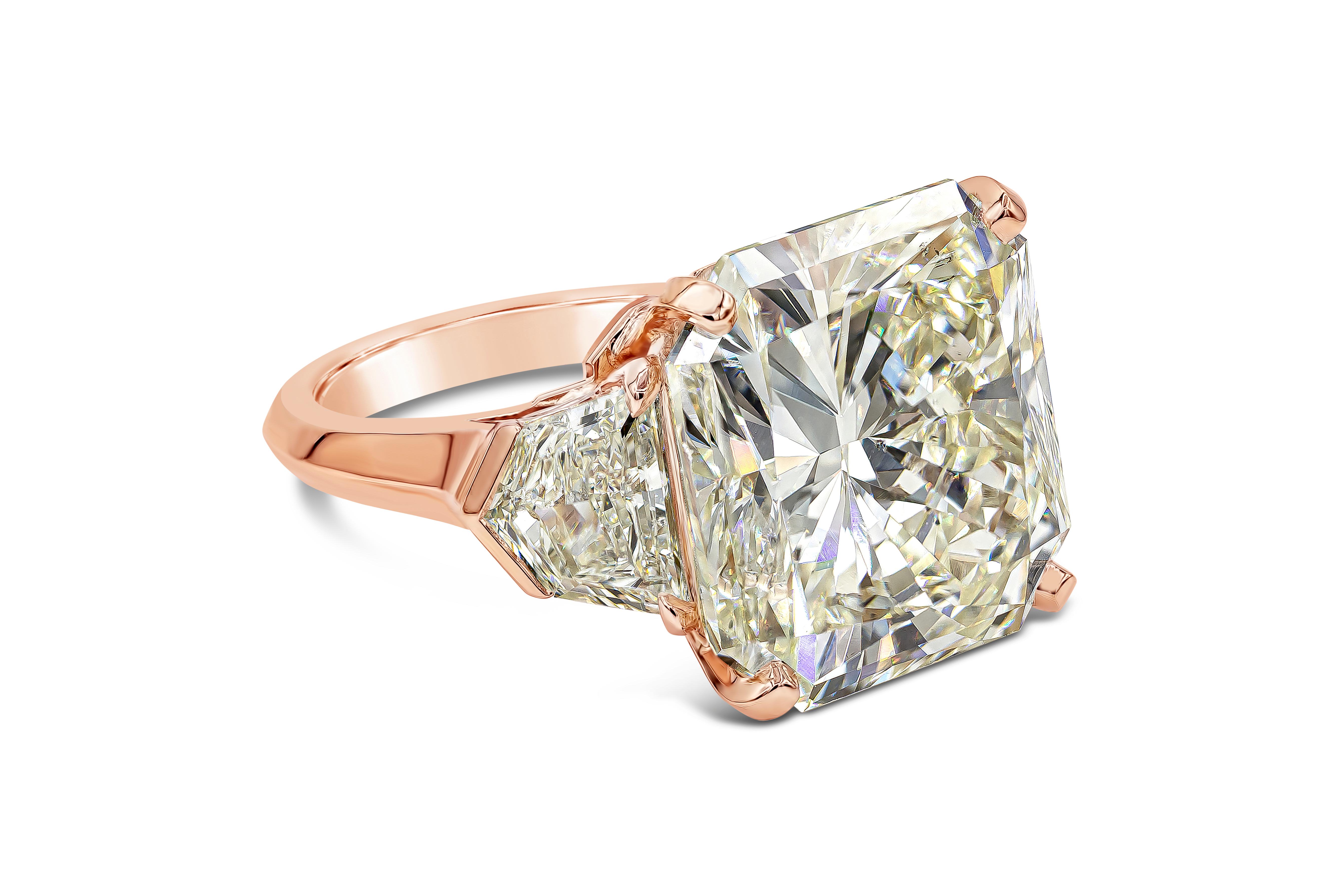 An immense center stone three stone engagement ring features a GIA Certified 20.05 carat, radiant cut diamond, O-P Color and SI1 in Clarity. Flanked by shield diamond on each side weighing 2.26 carats, O-P Color and VS in Clarity. Beautifully set in