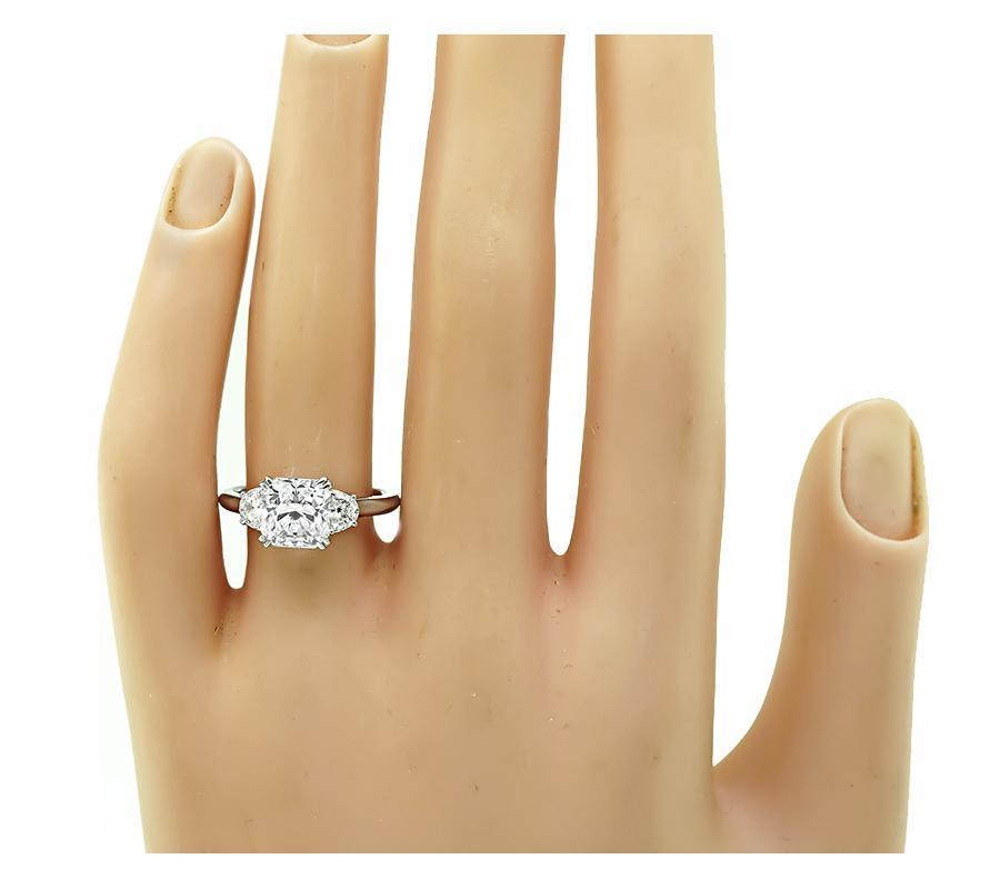 This is an amazing platinum engagement ring. The ring is centered with a sparkling GIA certified radiant cut diamond that weighs 2.01ct. The color of the diamond is H with VVS2 clarity. The center diamond is accentuated by dazzling half moon cut