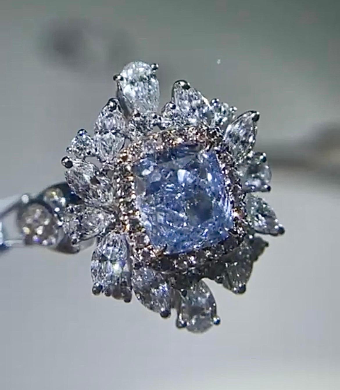 An exquisite GIA certified 2.02 carat cushion shaped Blue Diamond center stone, SI2 clarity, faint blue color - with VS quality white diamonds surrounding it set in solid 18K Gold. It is a convertible ring into pendant. It is a one of a kind,