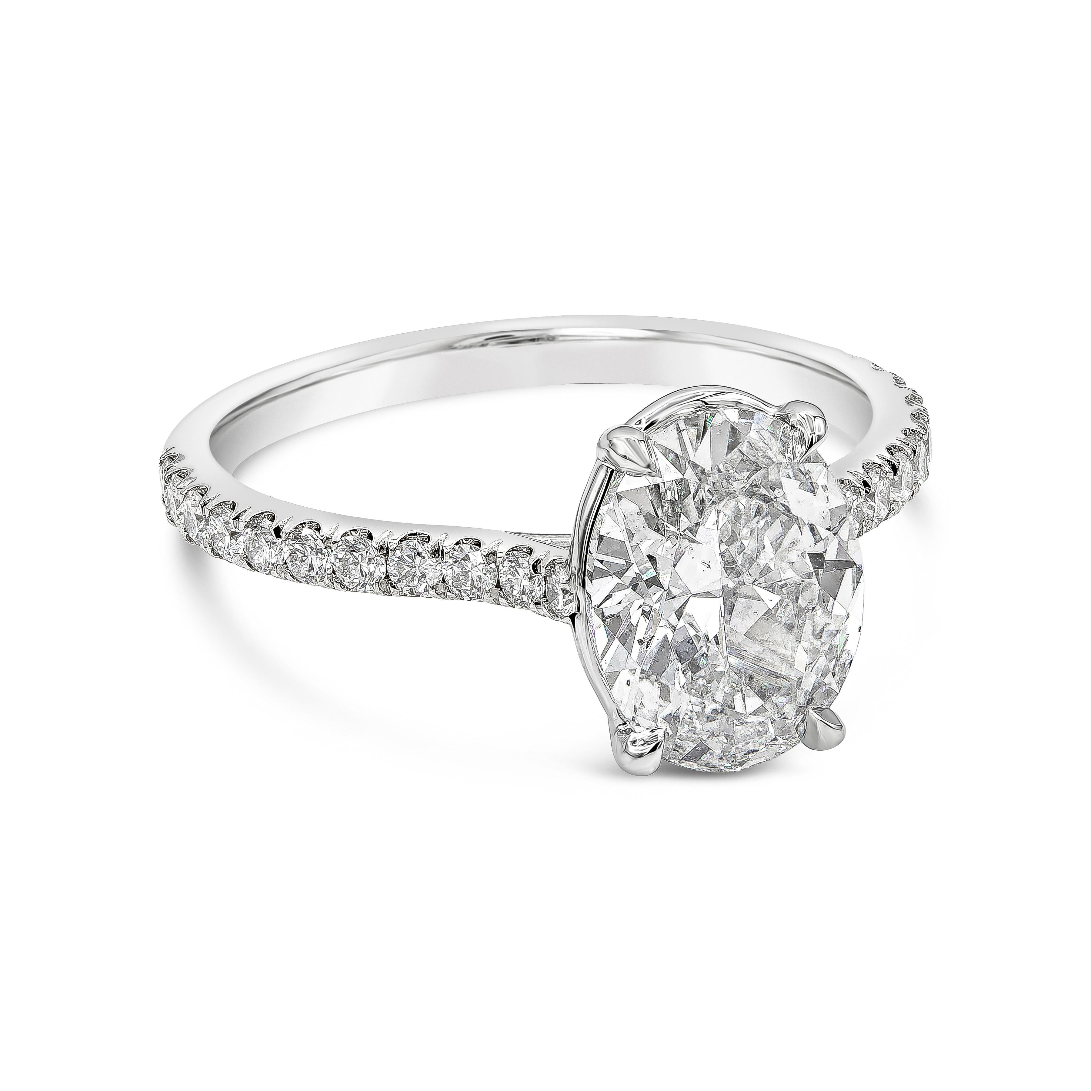 A timeless engagement ring showcasing a GIA Certified (G-SI1) oval cut diamond weighing 2.02 carats, set in a polished platinum mounting accented with round brilliant diamonds. Side diamonds weigh 0.32 carats total. Size 6.25 US (sizable upon
