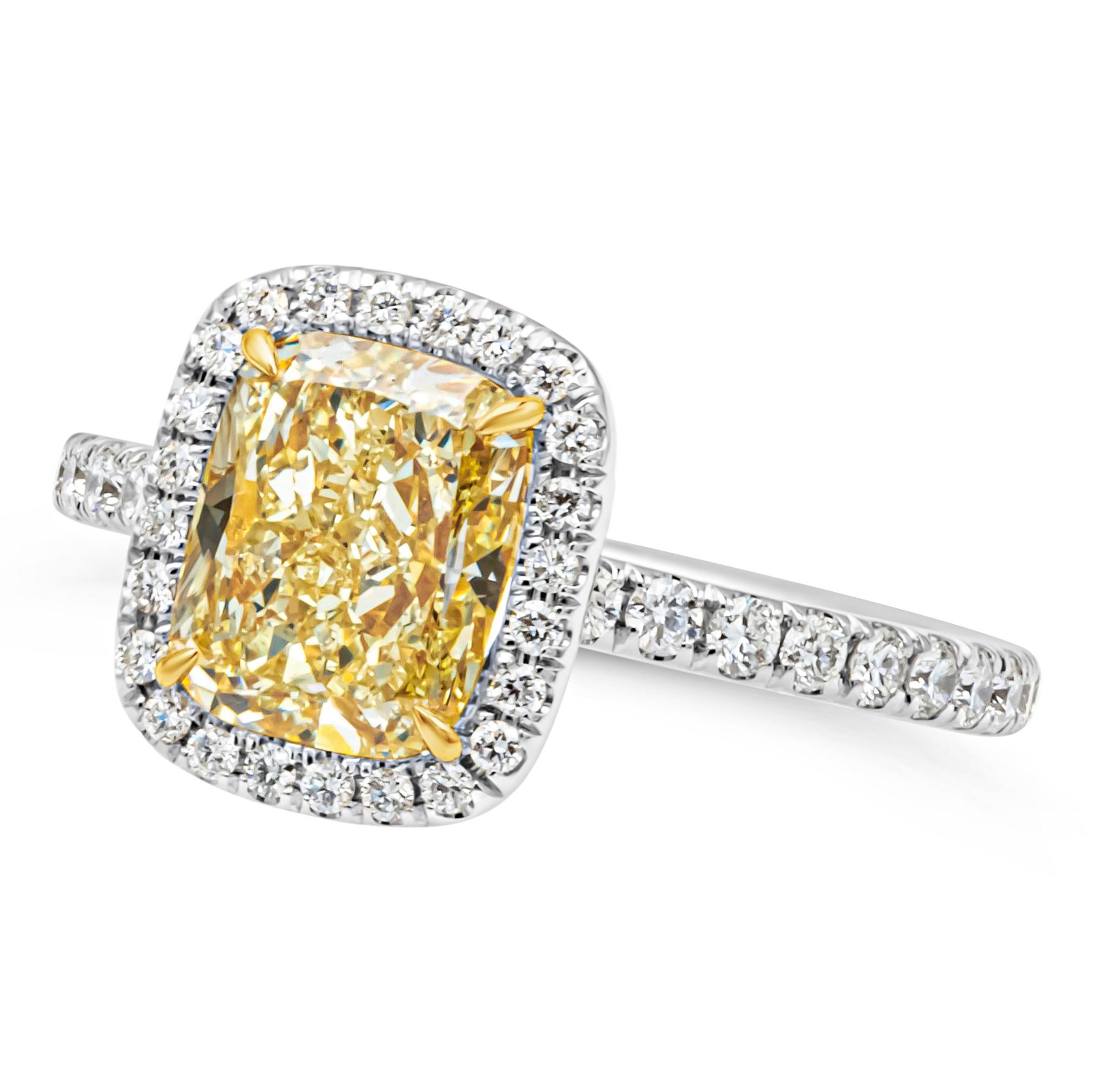 This gorgeous halo engagement ring features a 2.03 carats elongated cushion cut diamond certified by GIA as fancy yellow color and VS2 in clarity. Surrounded by brilliant round diamonds that continue to the shank of the ring weighing 0.66 carats