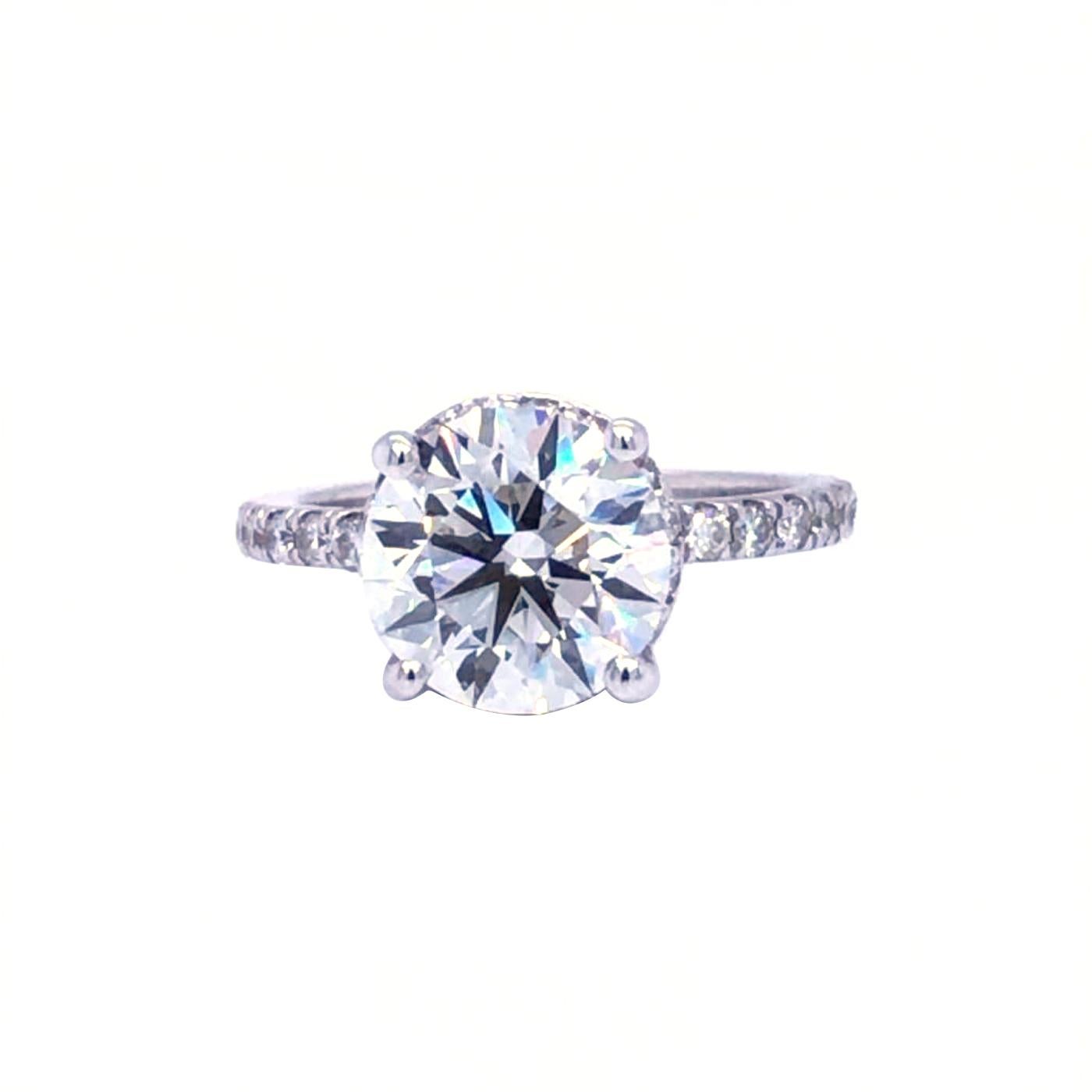 Timeless and elegant, The round brilliant cut diamond is framed with a Round shaped diamond halo, Adding to its appeal, the micro pave diamond halo and shank draw attention and add sparkle to the center stone. This outstanding engagement ring is