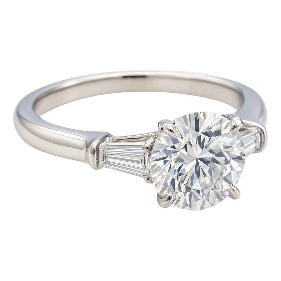 Au cœur de ce design exquis se trouve un diamant rond brillant de 2,05 carats certifié par le GIA (couleur H, pureté VS2), admiré pour sa présence lumineuse et ses proportions magnifiquement équilibrées. Sa très bonne taille et son excellent