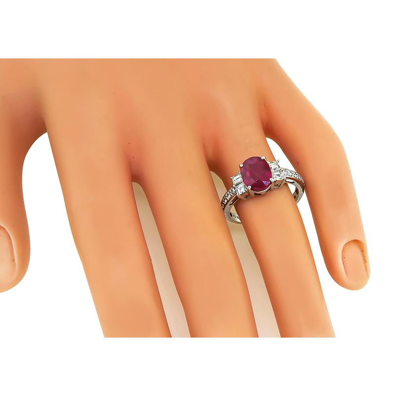 This is a stunning platinum engagement ring. The ring is centered with a lovely GIA certified oval cut no heat ruby that weighs 2.07ct. The center stone is accentuated by sparkling carre and round cut diamonds that weigh approximately 0.59ct. The