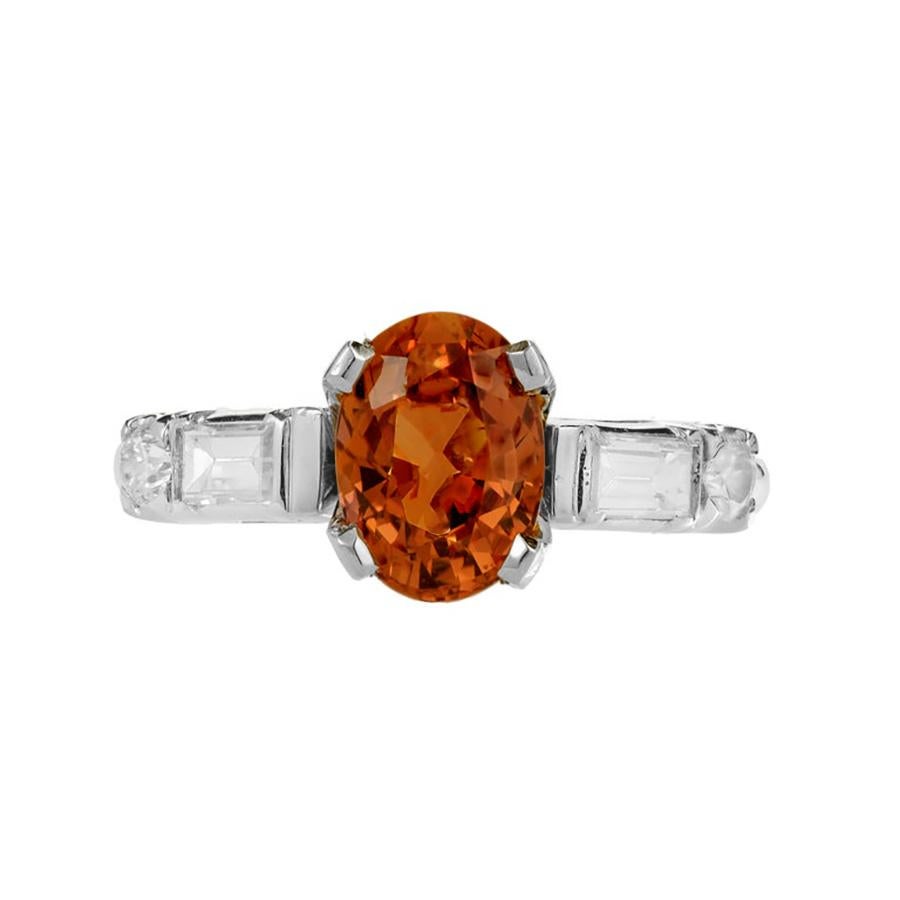 Anello di fidanzamento in platino con zaffiro arancione e diamante, unico nel suo genere, degli anni '50. La pietra centrale di questo gioiello è uno zaffiro ovale arancione naturale, senza calore, certificato GIA, di 2,08 carati, con 2 diamanti a