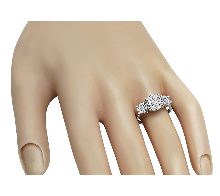 Il s'agit d'une superbe bague de fiançailles en platine. La bague est centrée sur un diamant étincelant de taille ronde certifié par la GIA, pesant 2.08ct. La couleur du diamant est I et sa pureté VS2. Le diamant central est accentué par deux