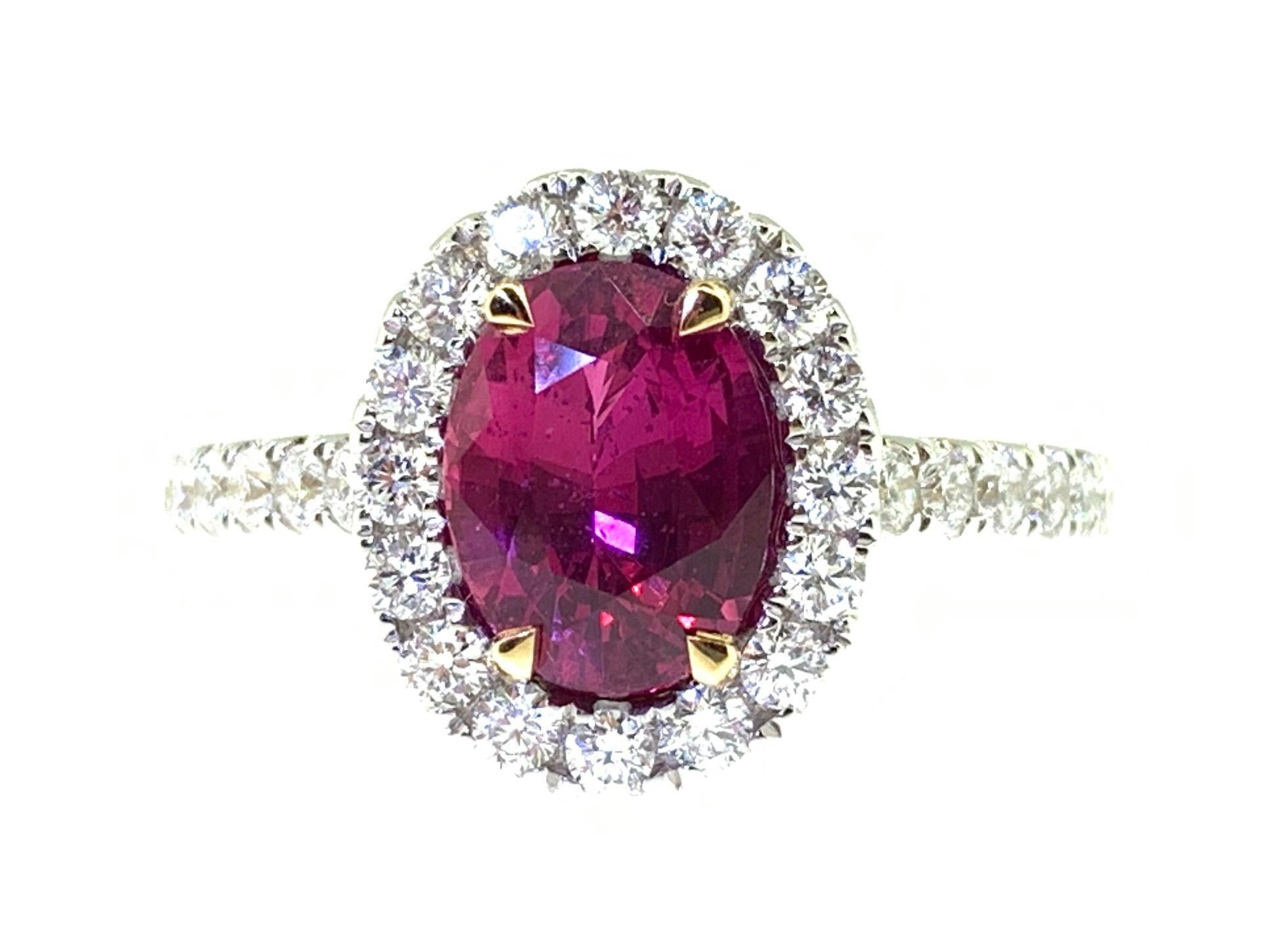This stunning cocktail ring features a beautiful GIA Certified 2.09 Carat Oval Ruby with a Diamond Halo on a Diamond Shank. This ring is set in 18k white gold, with 18k yellow gold prongs on the center stone. 
Total diamond weight = 0.59 carats.