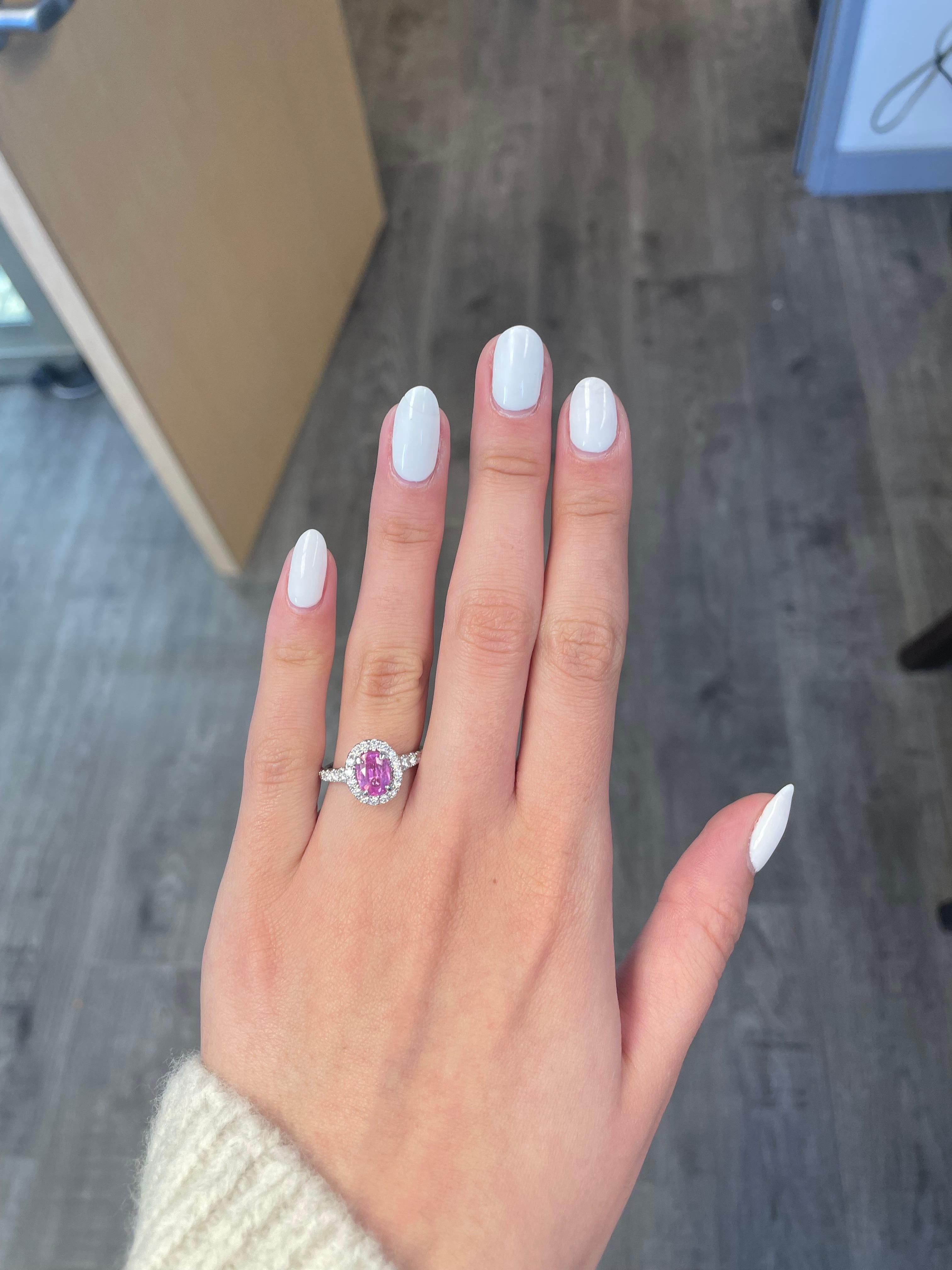 Schöner rosa Saphir mit Diamant Halo-Ring mit Diamant peek-a-boo, GIA zertifiziert.
1.41 Karat ovaler rosa Saphir, GIA zertifiziert Hitze. Ergänzt durch 32 runde Brillanten von 0,68 Karat. Ungefähr G/H Farbe und VS2/SI1 Klarheit. 18 Karat Weißgold,