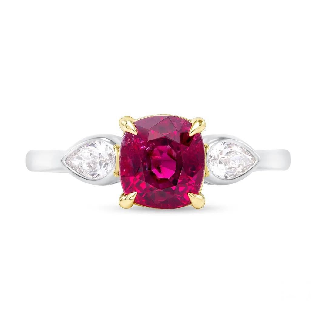 A 2.11-carat, untreated Ruby from Mozambique is accompanied by a GIA report. Crafted in 18K white with yellow gold, this enticing ruby displays a pure vibrant red color, supported by two pear-shaped diamonds totaling 0.29ct. 