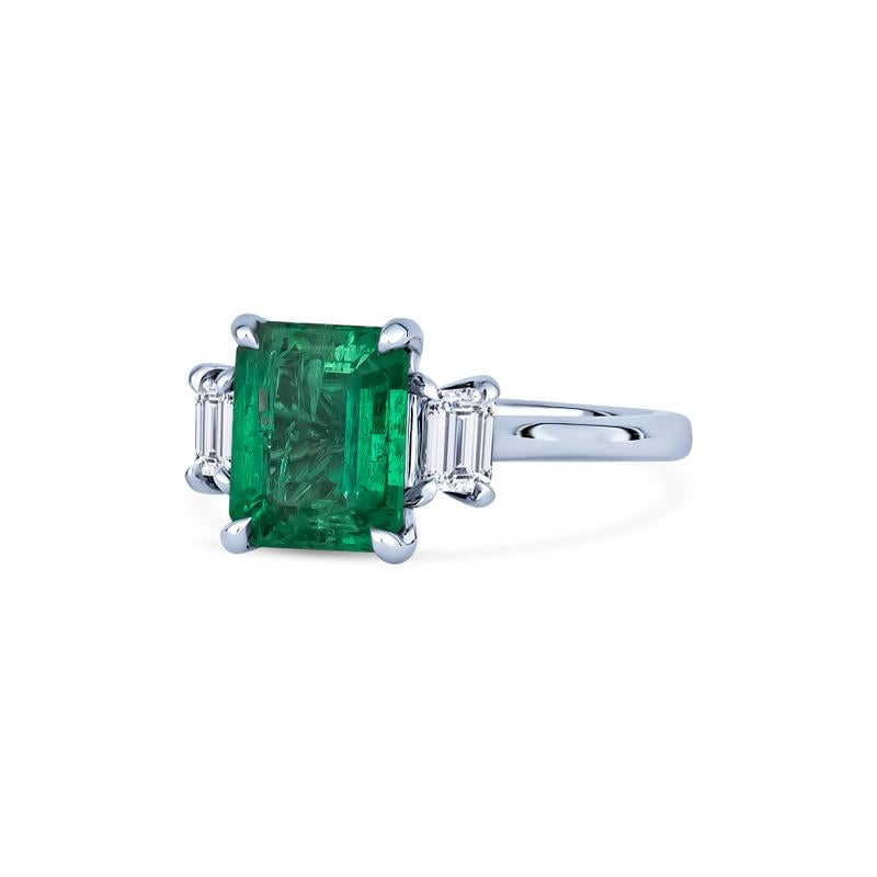 This exquisite ring features a 2.12ct emerald cut natural Columbian emerald set in 18k white gold. The center stone is accented by two emerald cut natural diamonds, totaling 0.41ctw, making this ring a classic addition to any jewelry collection.